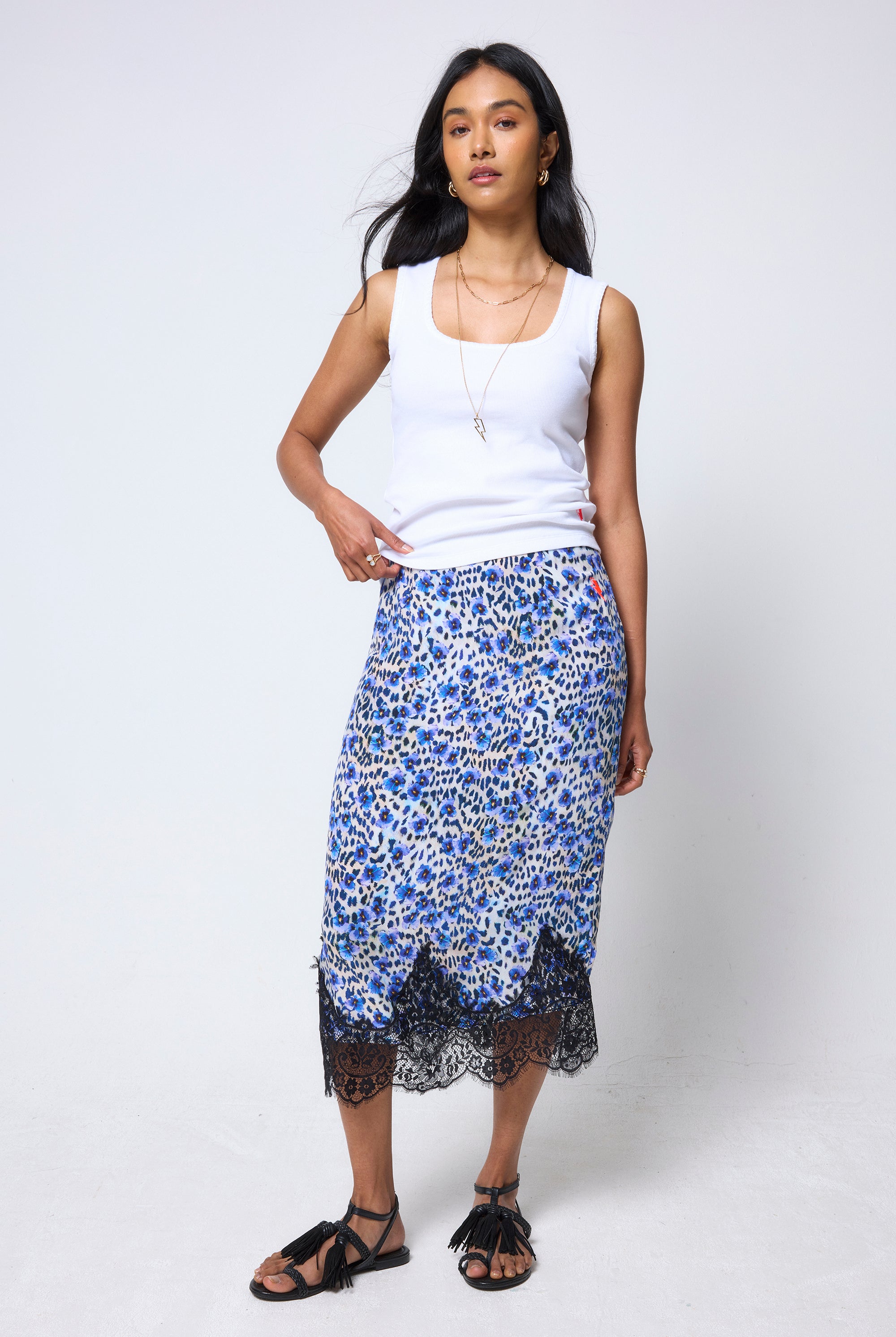 Scamp & Dude White Jersey Stitch Detail Vest Top | Model wearing a white vest top and blue floral cheetah print skirt with black lace trim on a white background