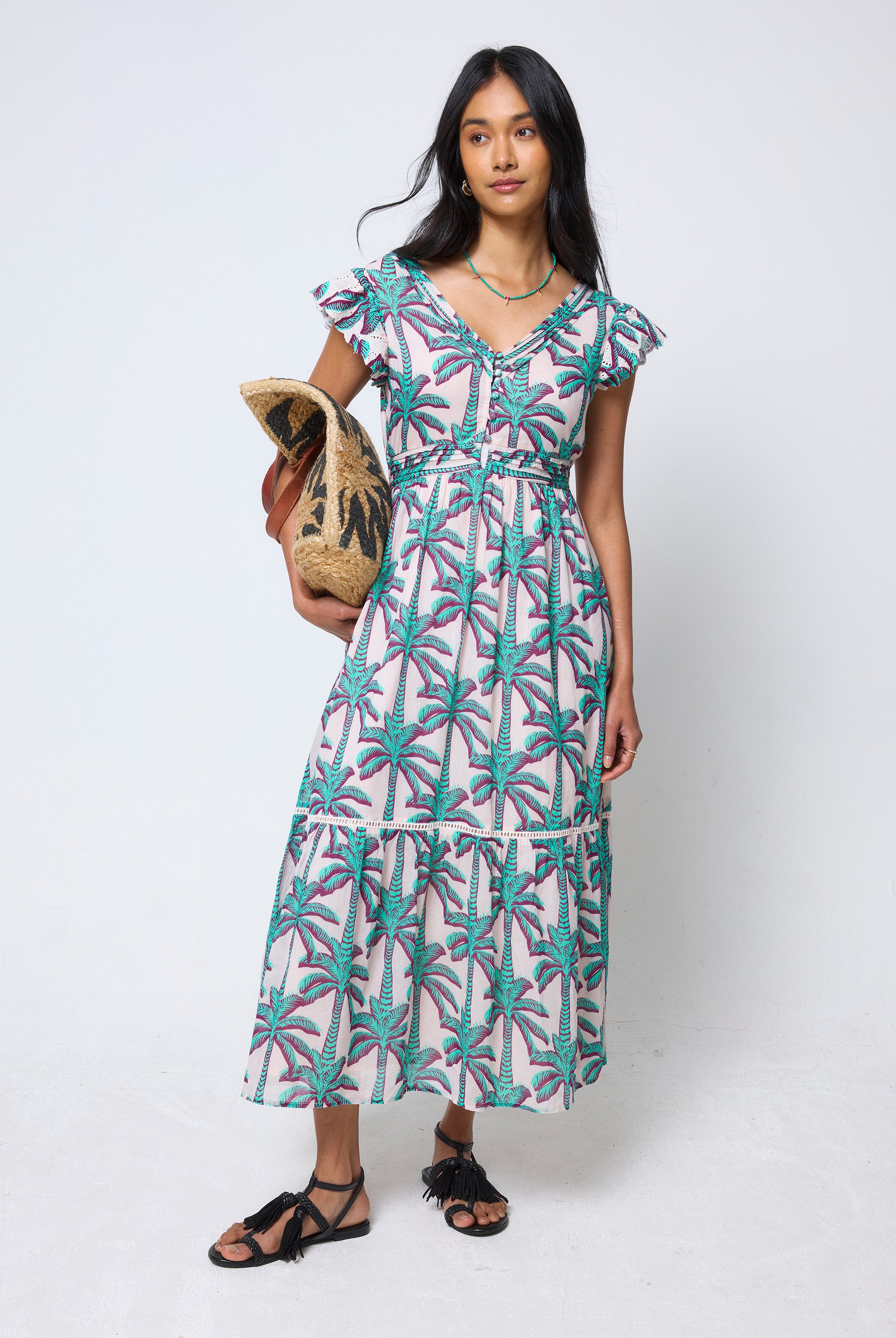 Scamp & Dude Cream with Green Shadow Palm Broderie Sleeve Pintuck Midi Dress | Model wearing a patterned dress holding a woven bag.