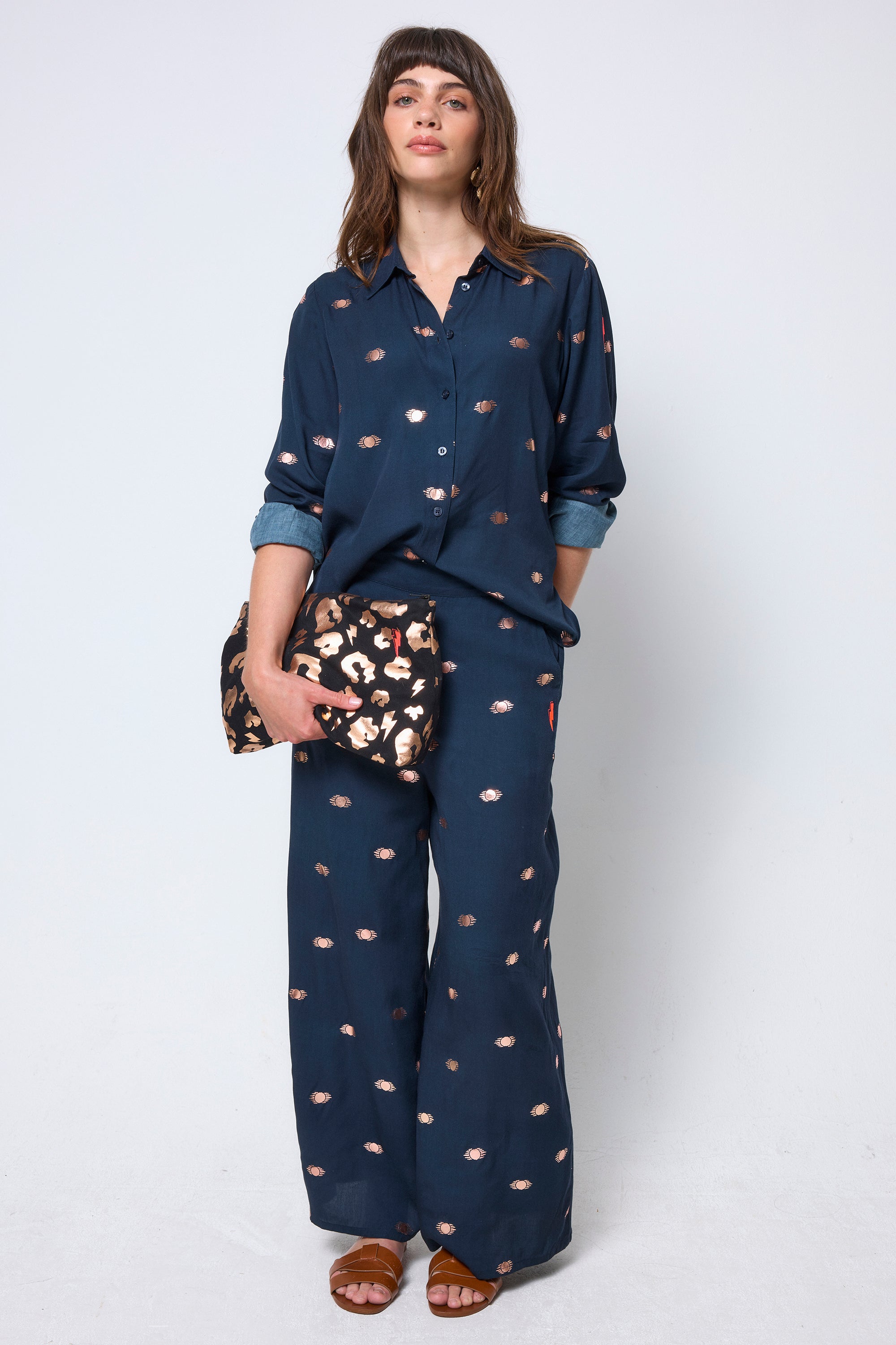 Scamp & Dude Navy with Gold Foil Shirt | Model wearing a navy shirt with foil print and matching wide leg trousers.