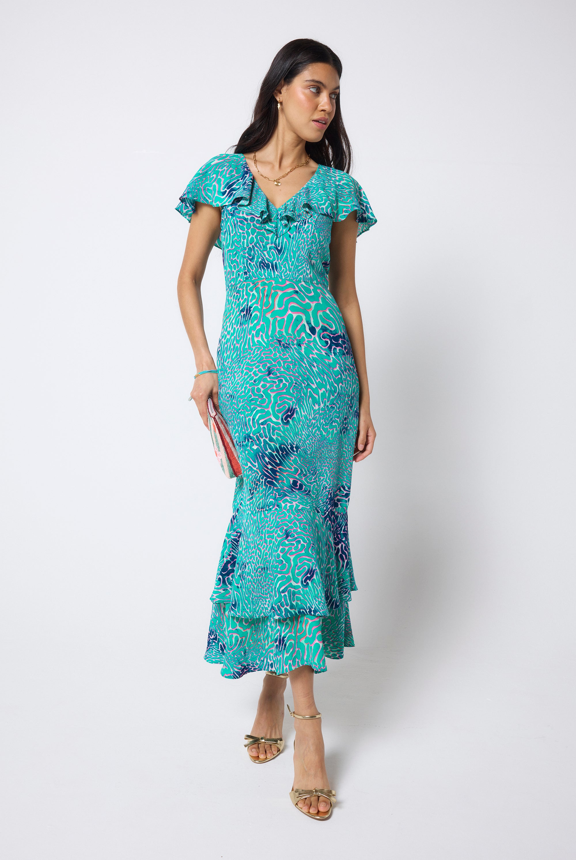Scamp & Dude Blue Ocean Scales Cape Sleeve Midi Dress | Model wearing a blue printed midi dress with ruffle detail with gold high heels.