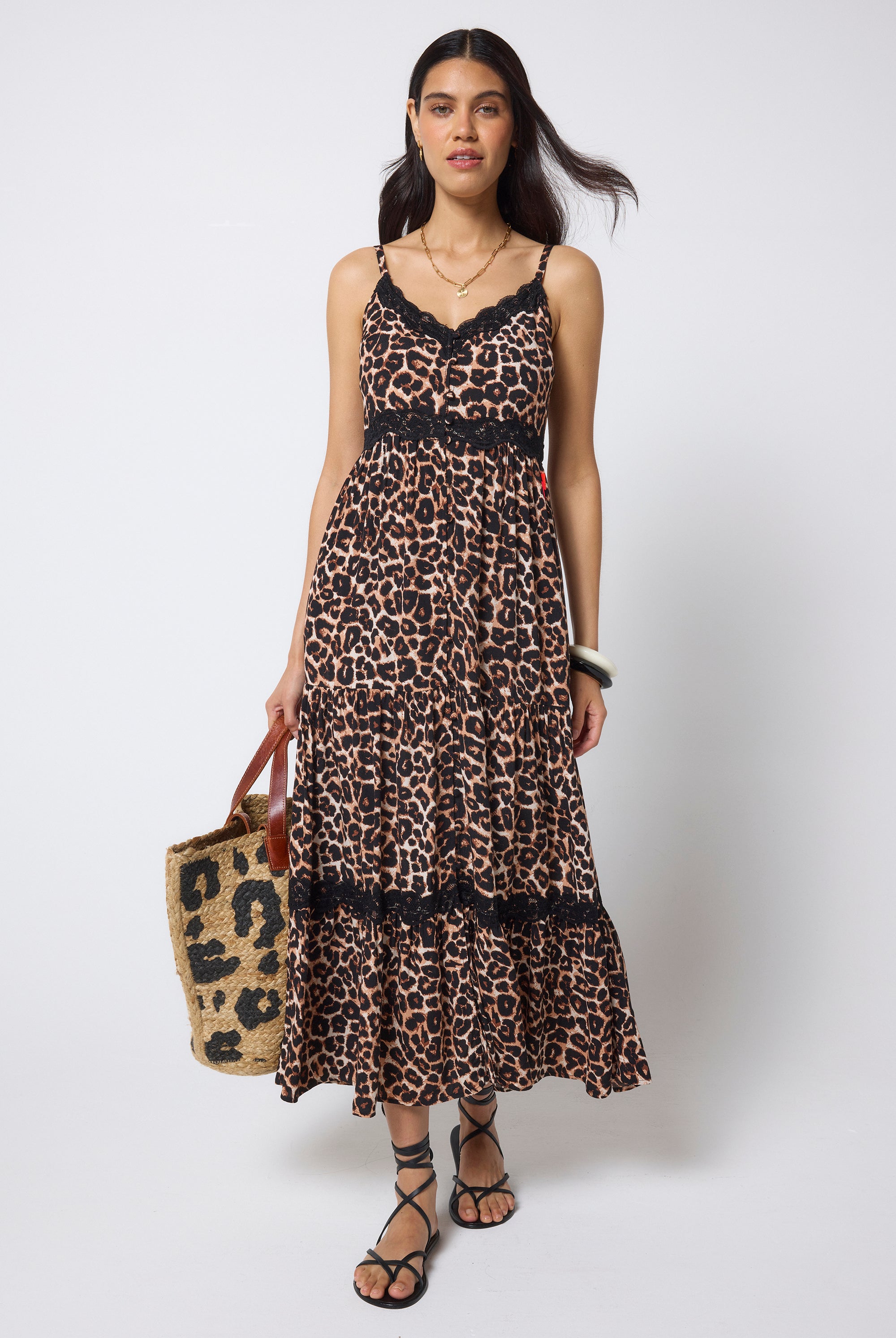 Scamp & Dude Neutral Jaguar Lace Trim Midi Sundress | Model wearing a neutral jaguar print sundress with delicate black lace trim detail. Worn with black flat sandals and a straw bag.