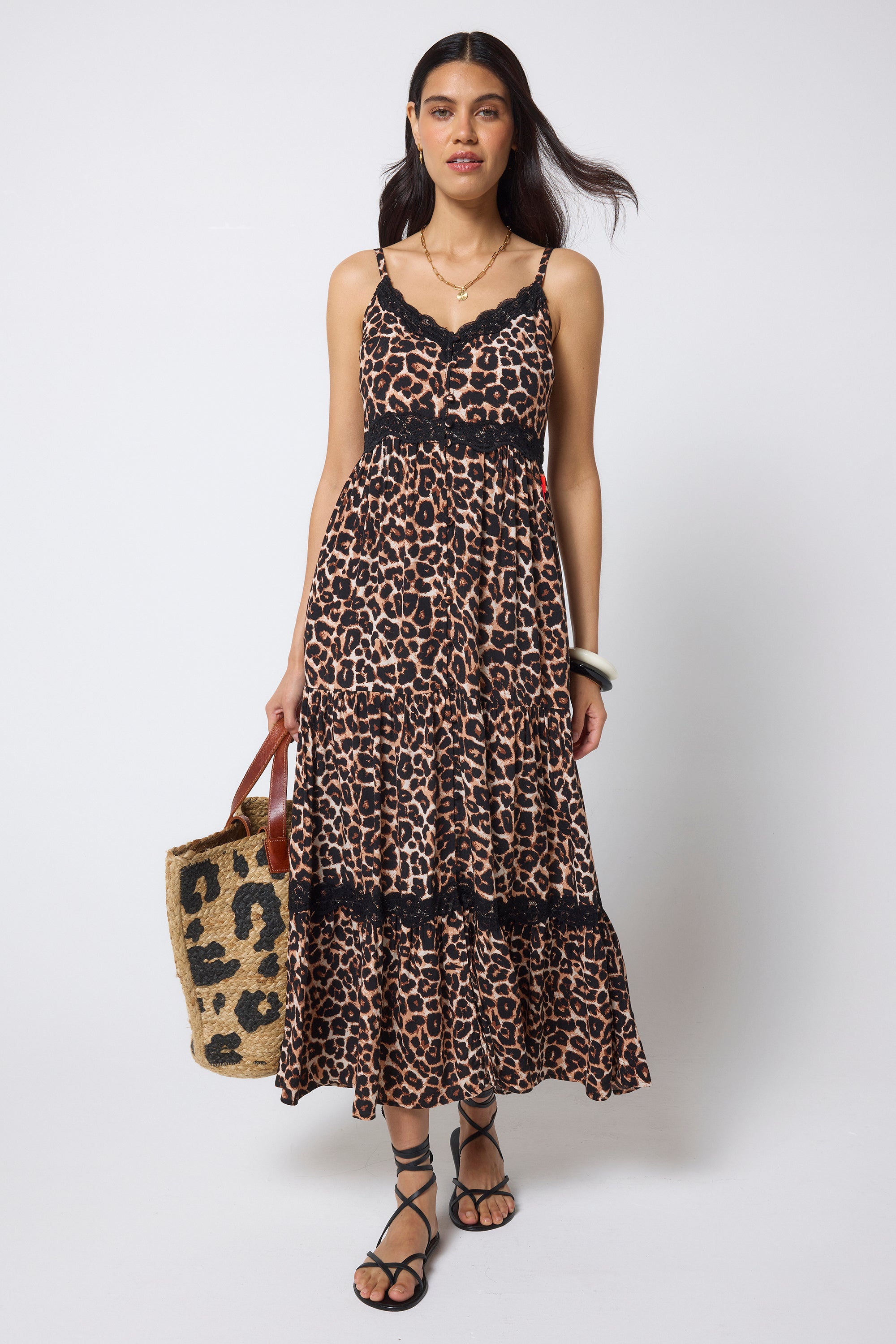 Scamp & Dude Neutral Jaguar Lace Trim Midi Sundress | Model wearing a neutral jaguar print sundress with delicate black lace trim detail. Worn with black flat sandals and a straw bag.