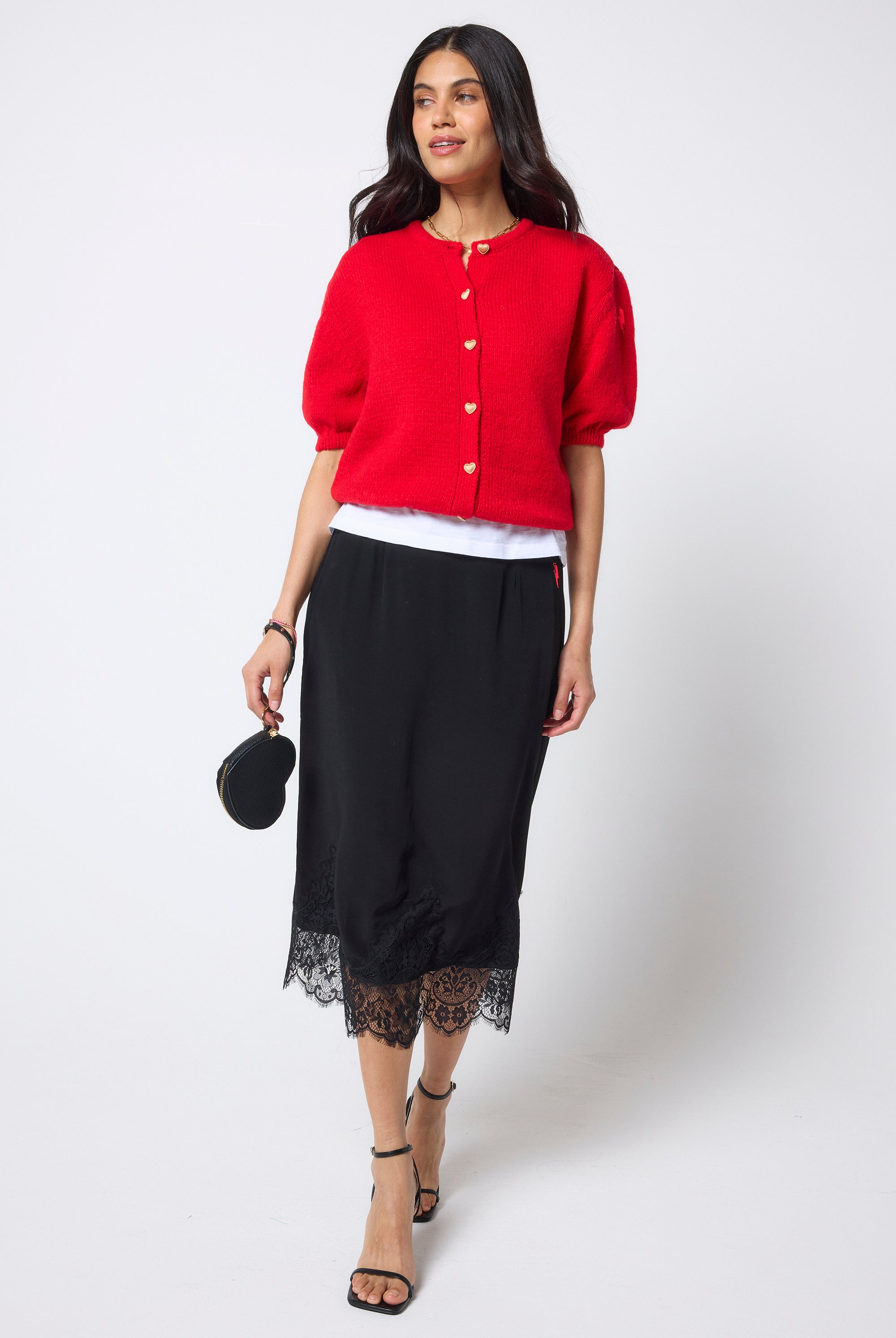 Scamp & Dude Black Lace Trim Midi Slip Skirt | Model wearing a black lace trim midi skirt with a white vest and red short sleeve cardigan.