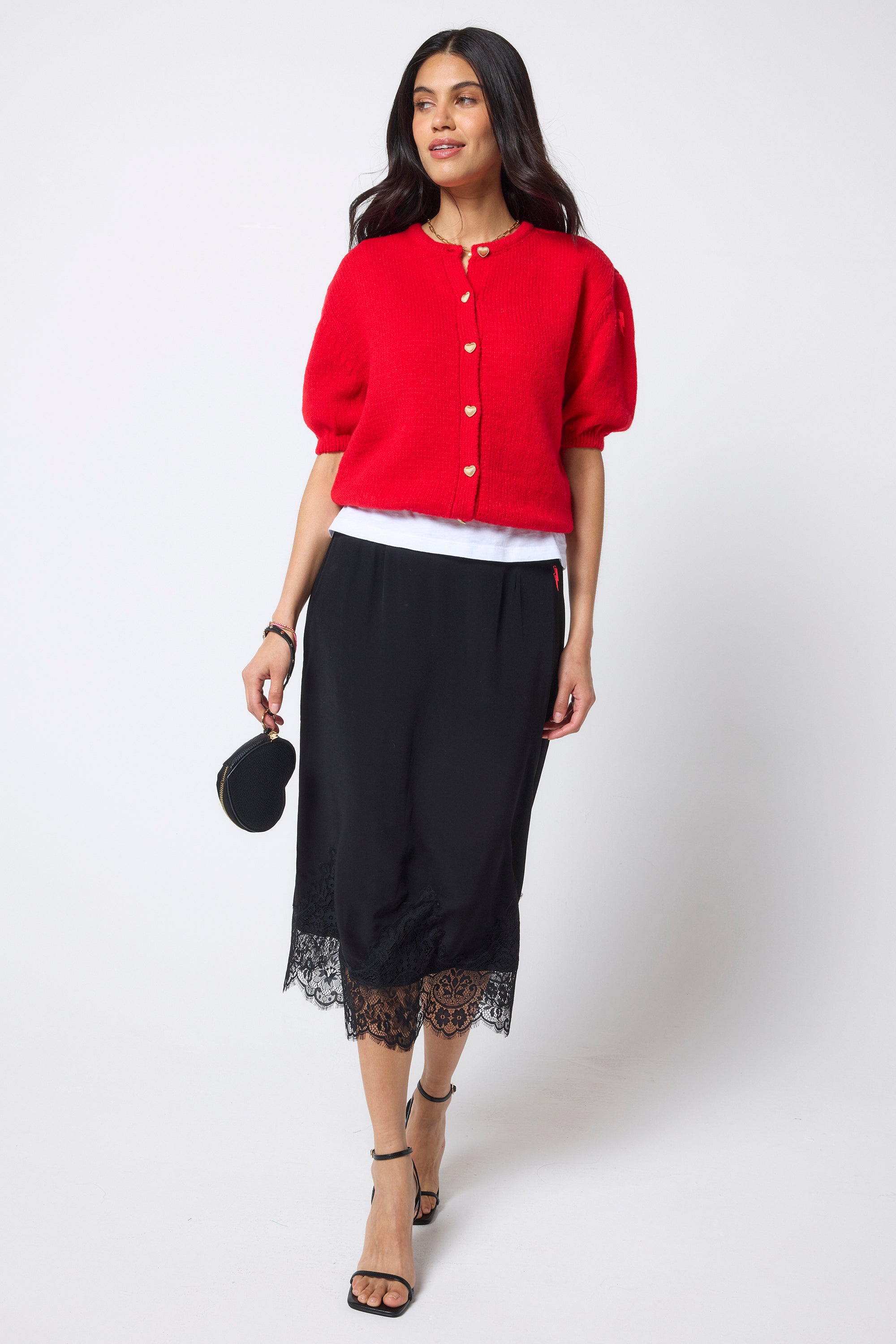 Scamp & Dude Black Lace Trim Midi Slip Skirt | Model wearing a black lace trim midi skirt with a white vest and red short sleeve cardigan.