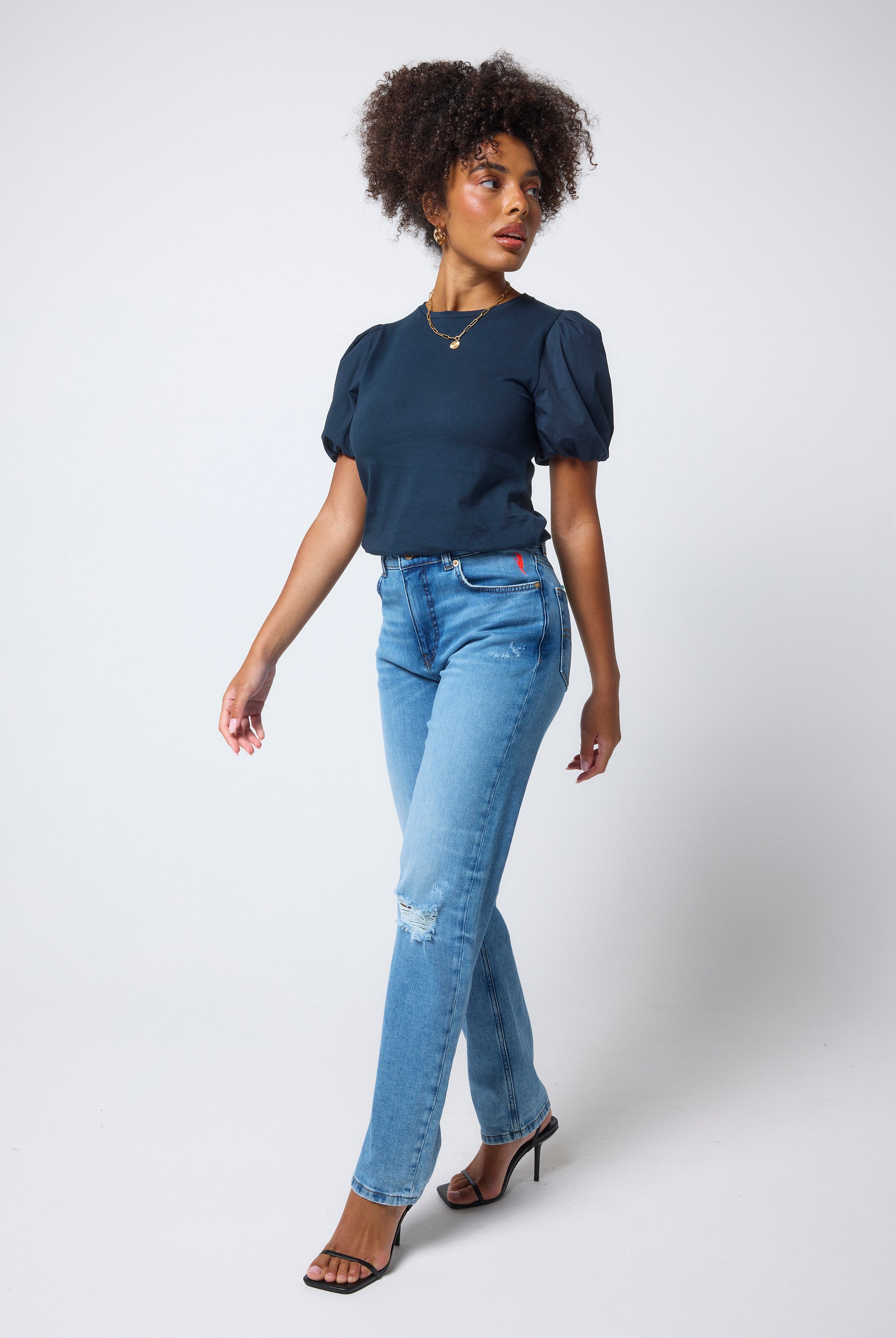 Scamp & Dude Navy Puff Sleeve T-Shirt | Model wears a navy puff sleeve t-shirt with distressed jeans and black high heels.