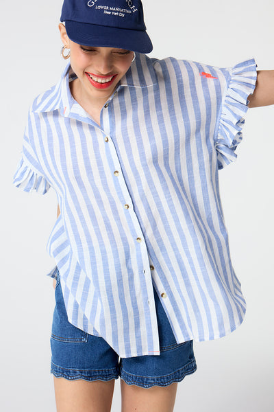 Scamp and Dude Blue and White Stripe Frill Sleeve Shirt | Model wearing blue and white stripe shirt featuring frill sleeves and paired with scallop hem denim shorts.