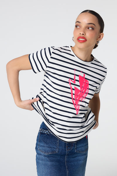 Scamp and Dude Cream with Navy Stripe and Neon Pink Glitch Bolt T-Shirt | Model wearing a cream round neck t shirt with navy stripes and a large neon pink lightning bolt printed on the front.