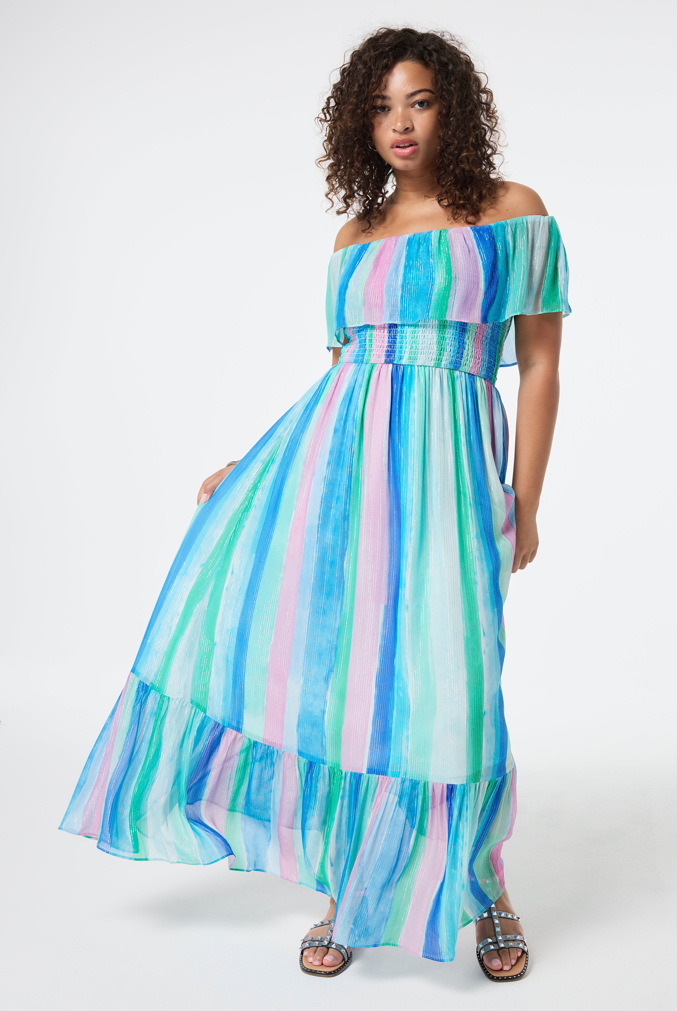 Scamp and Dude Rainbow Stripe Bardot Maxi Dress | Model wearing a bardot maxi dress in a rainbow painted stripe with lurex detail.