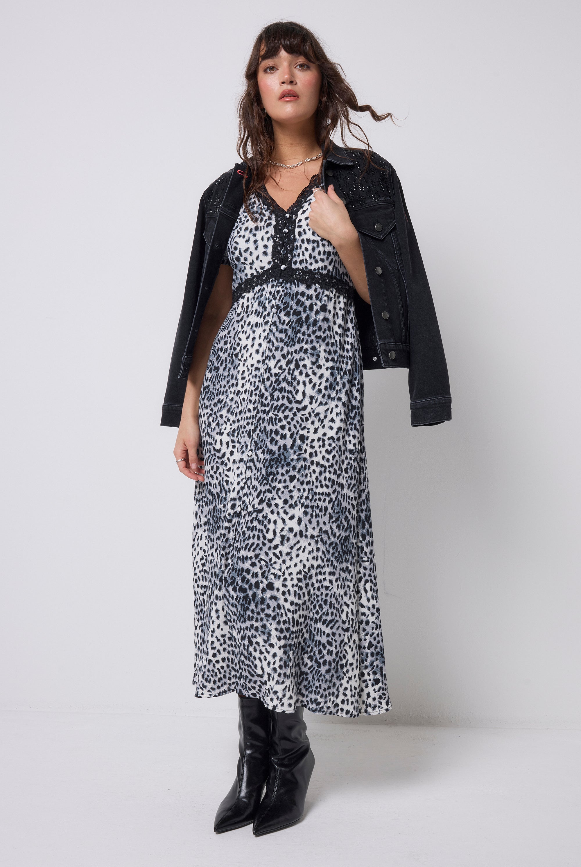 Scamp & Dude Grey Cheetah Lace Trim Puff Sleeve Midi Tea Dress | Model wearing a cheetah print dress with a black jacket and boots on a white background.