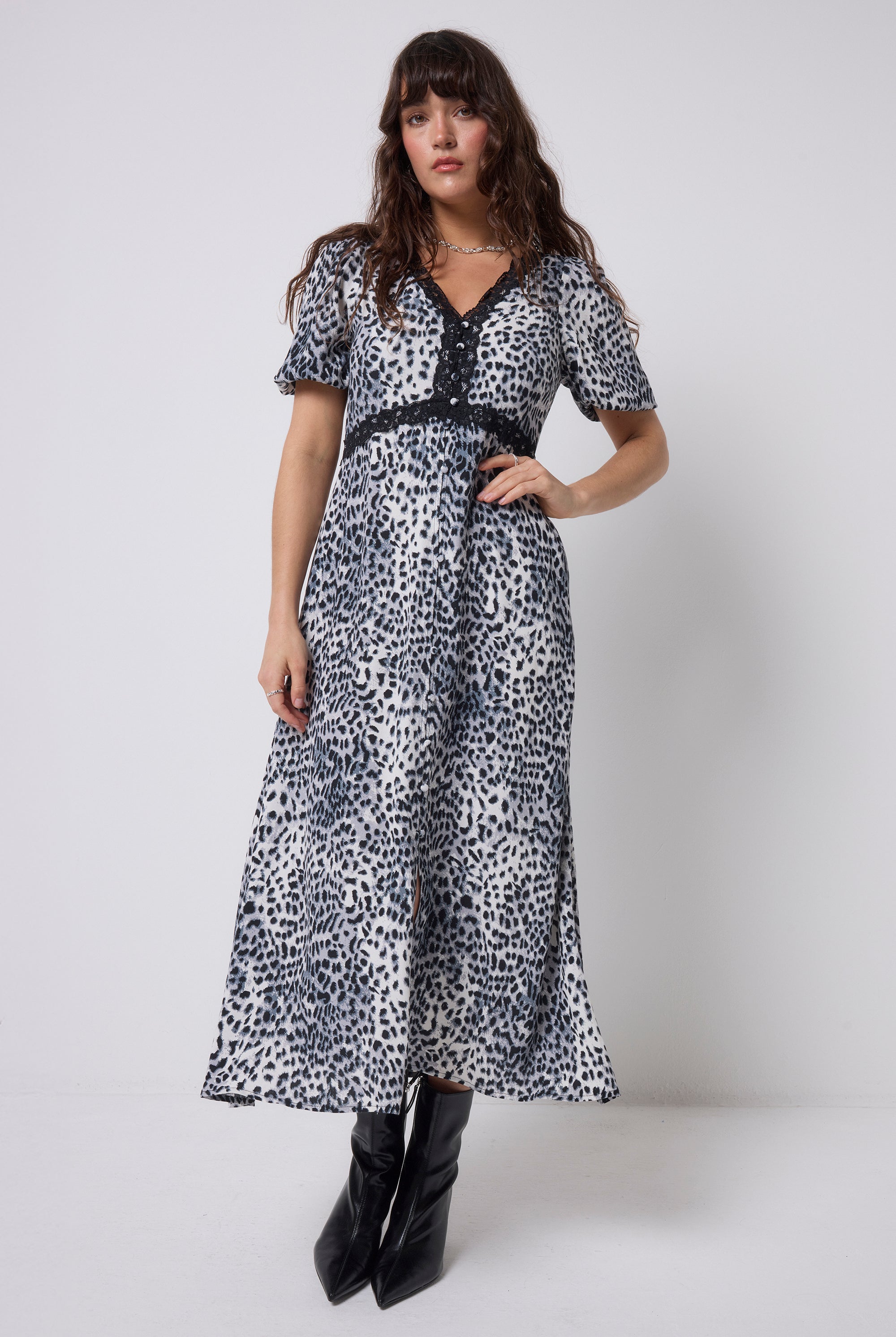 Scamp & Dude Grey Cheetah Lace Trim Puff Sleeve Midi Tea Dress | Model wearing a cheetah print dress and boots on a white background.