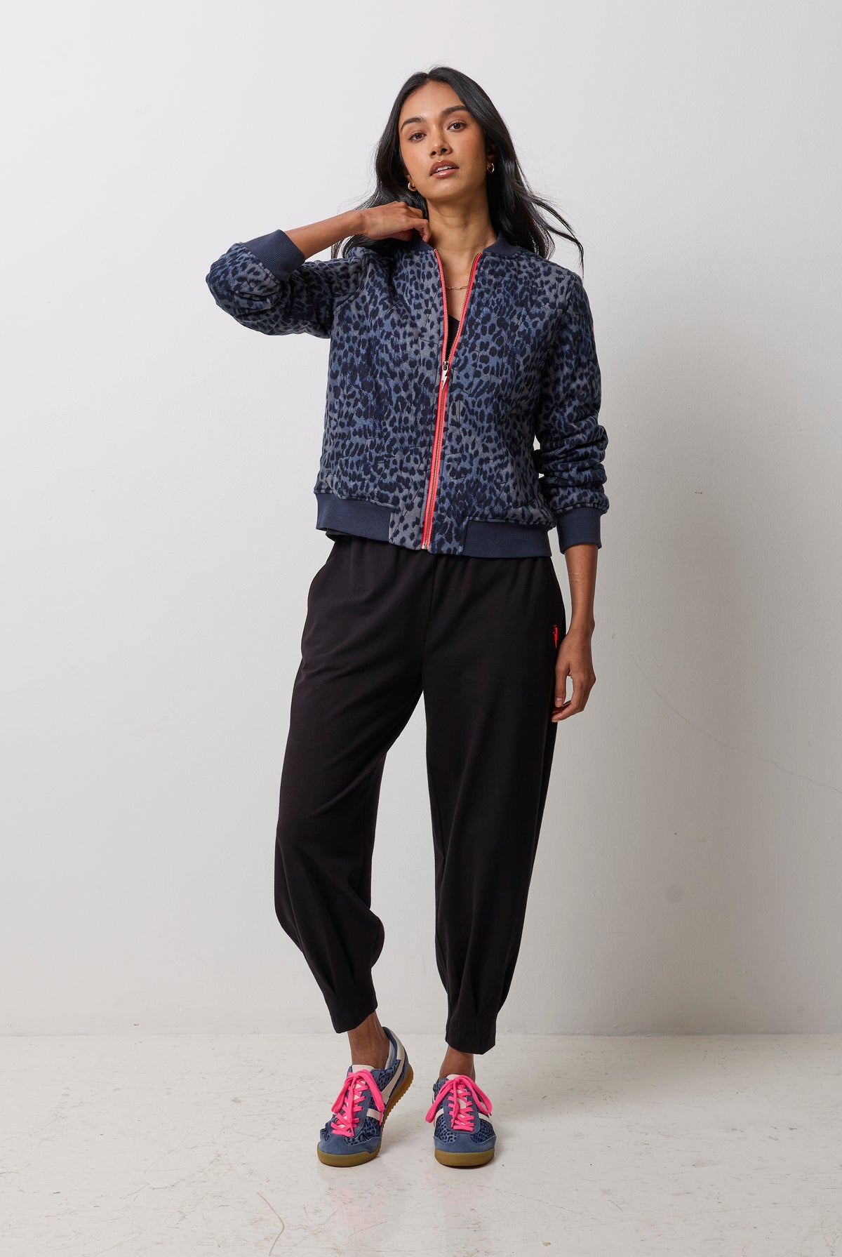 Scamp & Dude Navy Cheetah Fitted Bomber Jacket | Model wearing a pair of black barrel leg joggers with a black t-shirt and navy cheetah print bomber jacket.