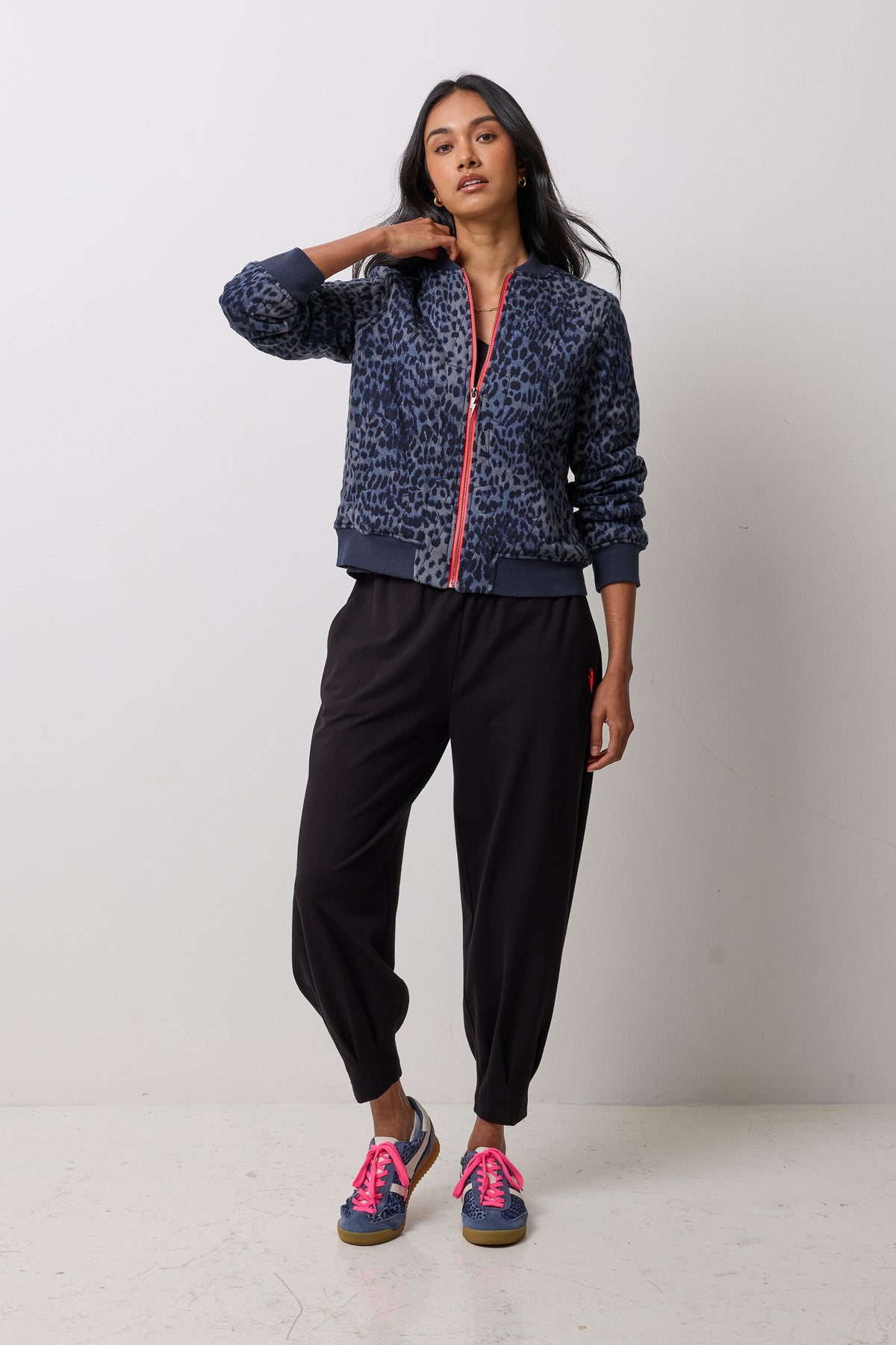 Scamp & Dude Navy Cheetah Fitted Bomber Jacket | Model wearing a pair of black barrel leg joggers with a black t-shirt and navy cheetah print bomber jacket.