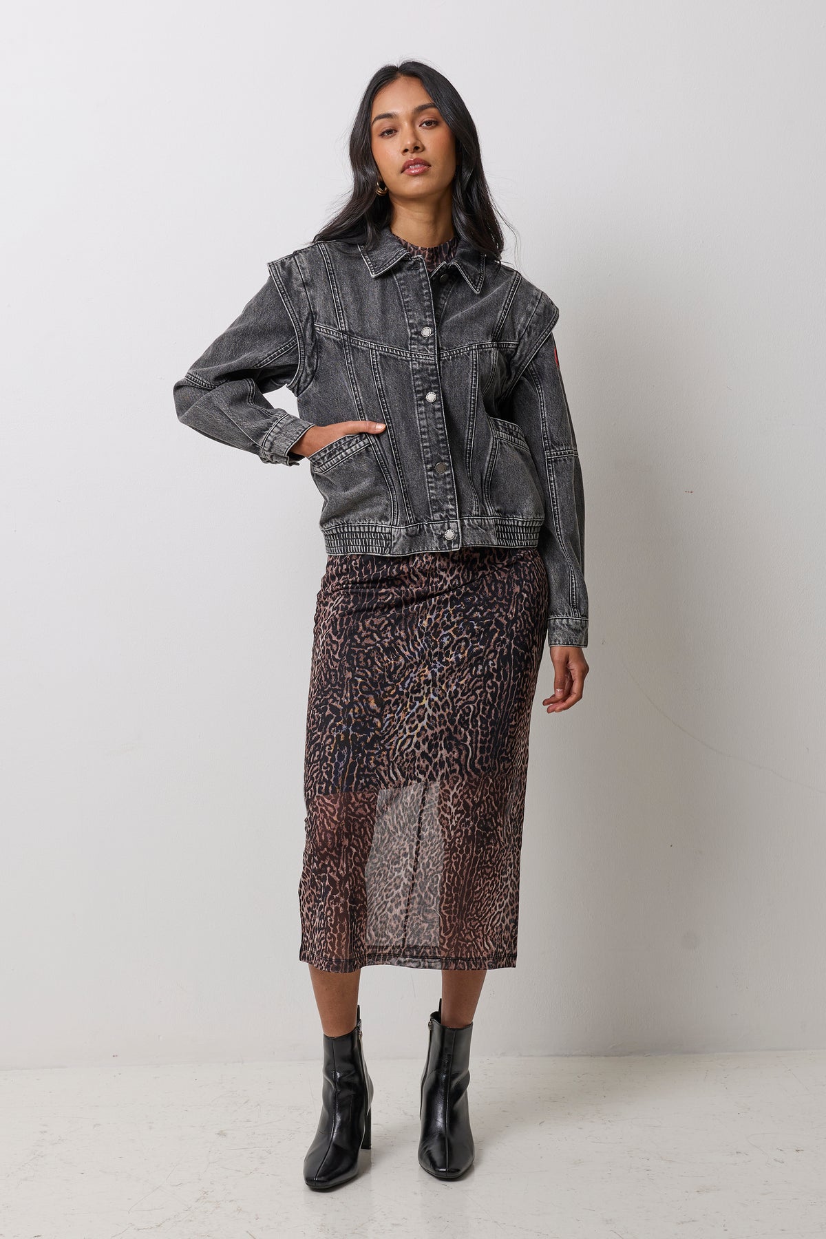 Scamp & Dude Washed Black Seam Detail Denim Jacket | Model wearing a neutral mesh cheetah print dress with a black denim jacket featuring seam detail. Worn with black heeled boots.