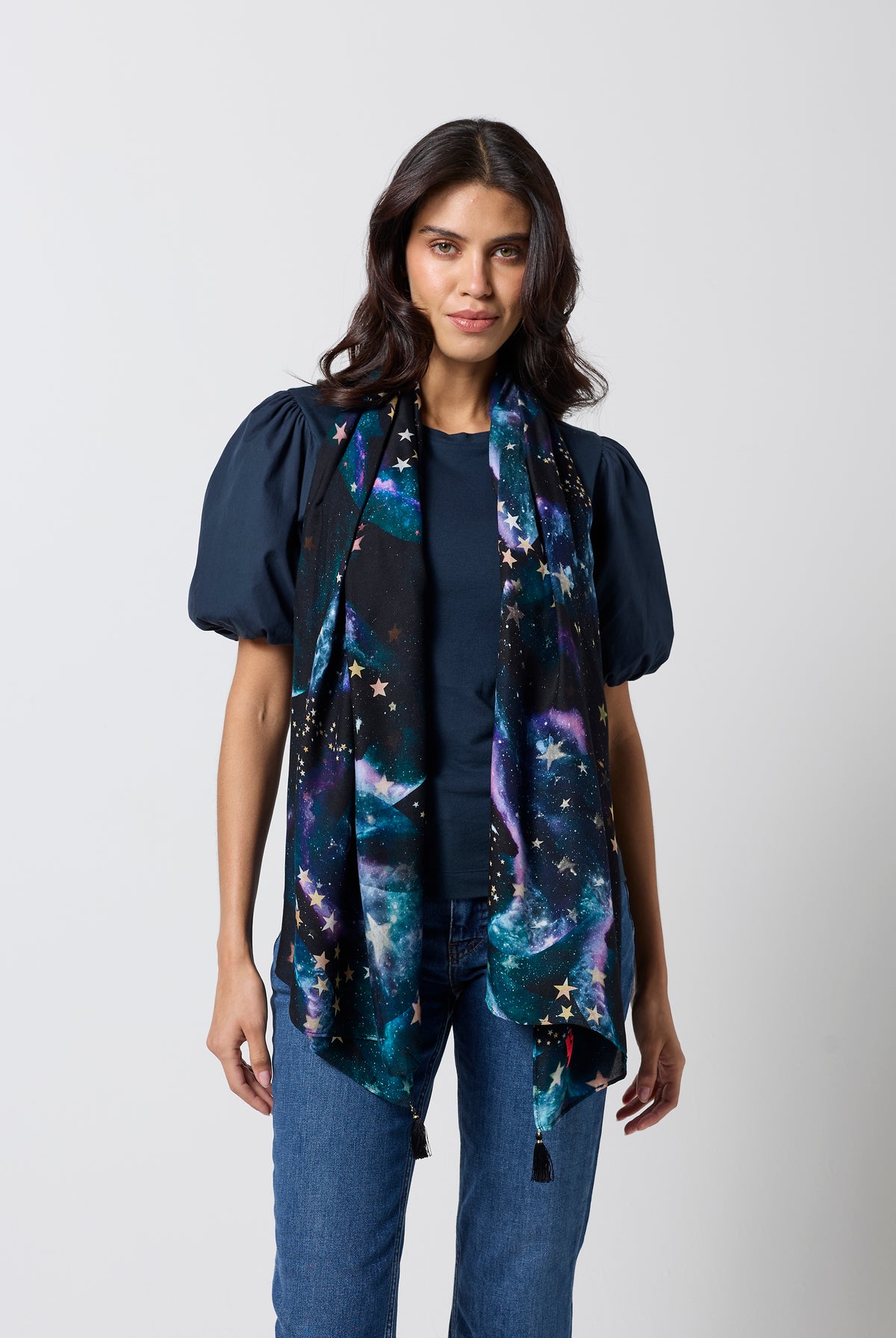 Scamp & Dude Black Galaxy with Stars Charity Super Scarf | Model wearing a navy puff sleeve t-shirt with a galaxy print super scarf and blue jeans.