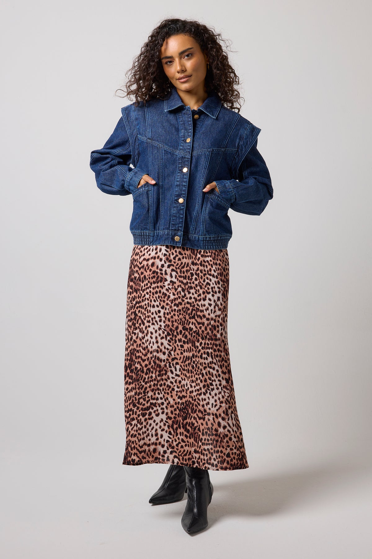 Scamp & Dude Mid Wash Seam Detail Denim Jacket | Model wearing a cropped blue denim jacket and a brown leopard-print midi dress, paired with black ankle boots.
