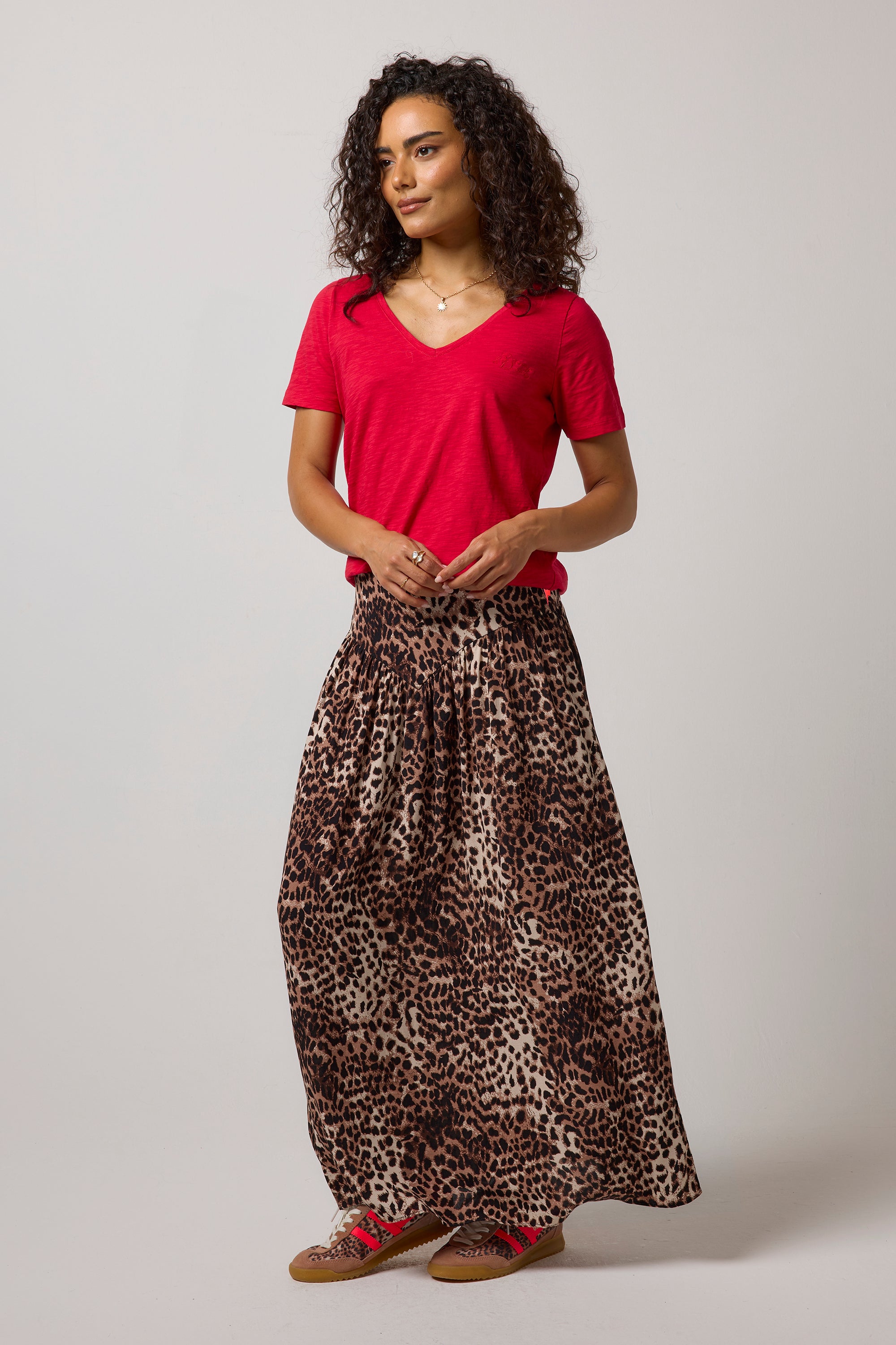 Scamp & Dude Neutral with Black Cheetah Drop Waist Midi Skirt| Model wearing a cheetah drop waist midi skirt paired with a red v-neck t-shirt.