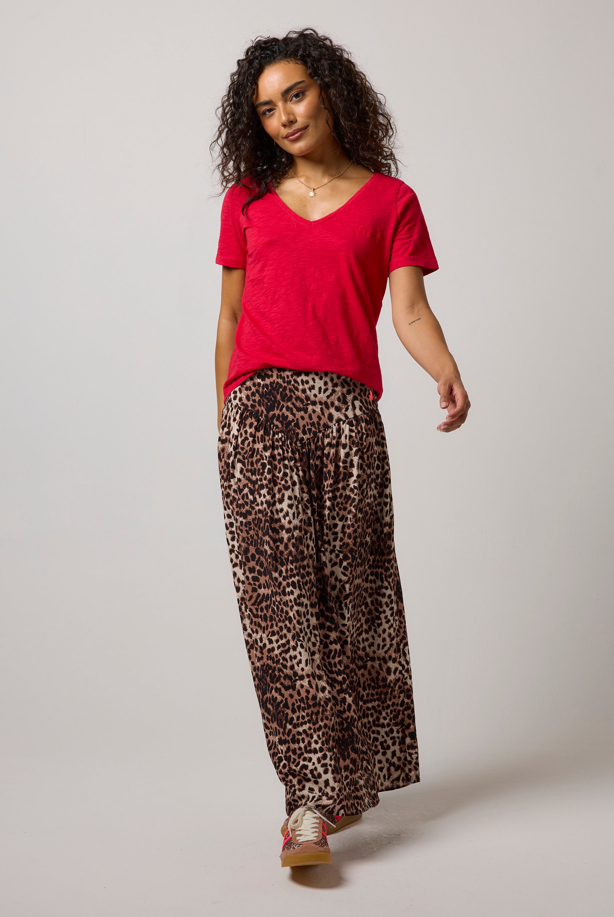 Scamp & Dude Neutral with Black Cheetah Drop Waist Midi Skirt| Model wearing a cheetah drop waist midi skirt paired with a red v-neck t-shirt.