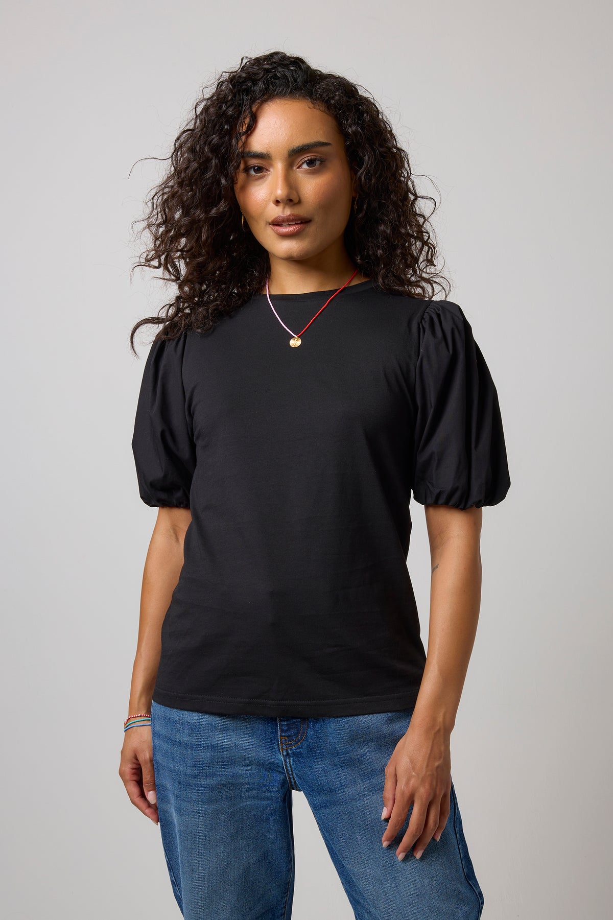 Scamp & Dude Black Puff Sleeve T-Shirt | Model wearing a black puff sleeve t-shirt with a pair of blue jeans.