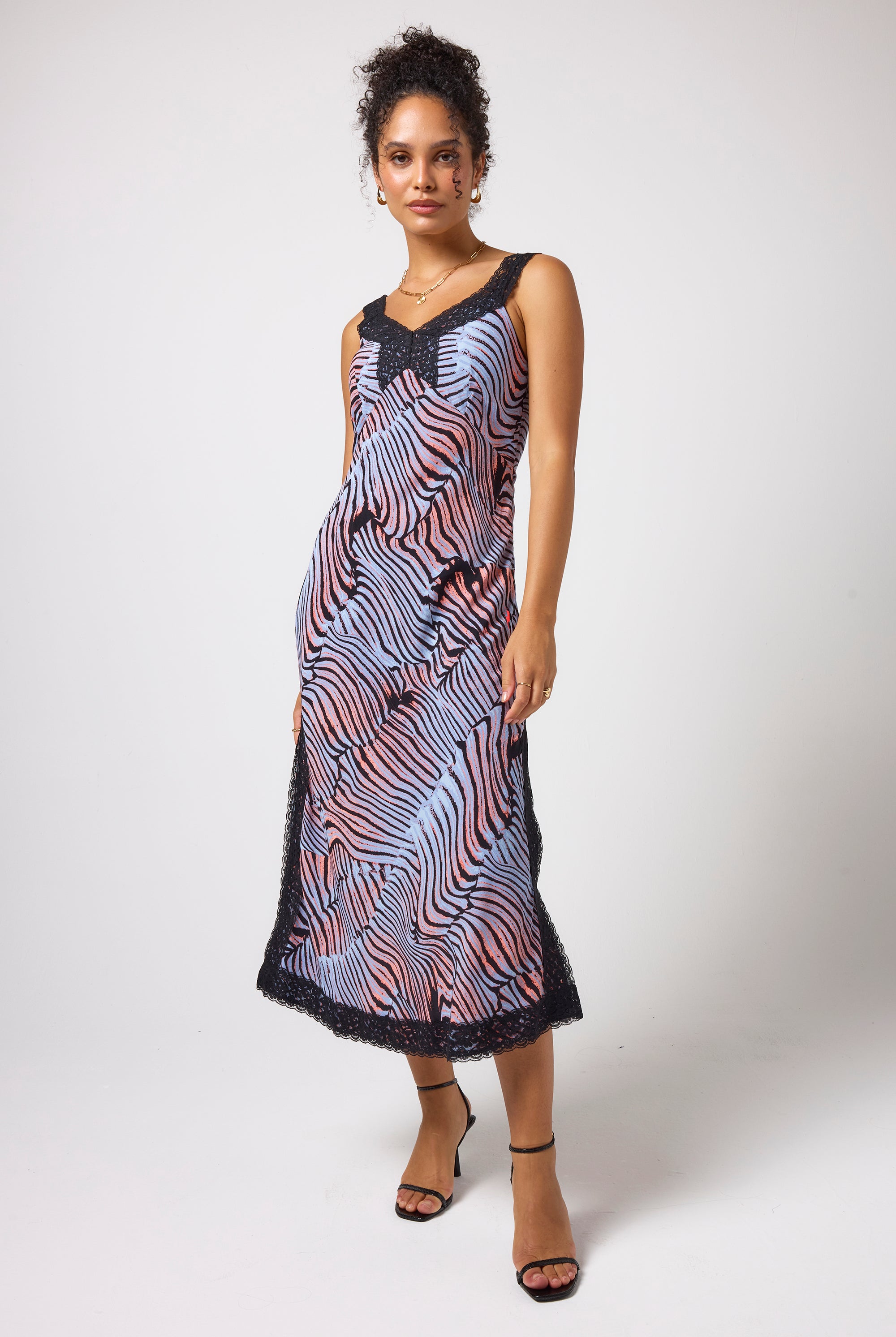 Scamp & Dude Blue with Coral and Black Tiger Moth Lace Detail Midi Slip Dress | Model wearing a sleeveless midi dress with a coral, blue, and black tigermoth pattern and black lace trim at the neckline and hem.