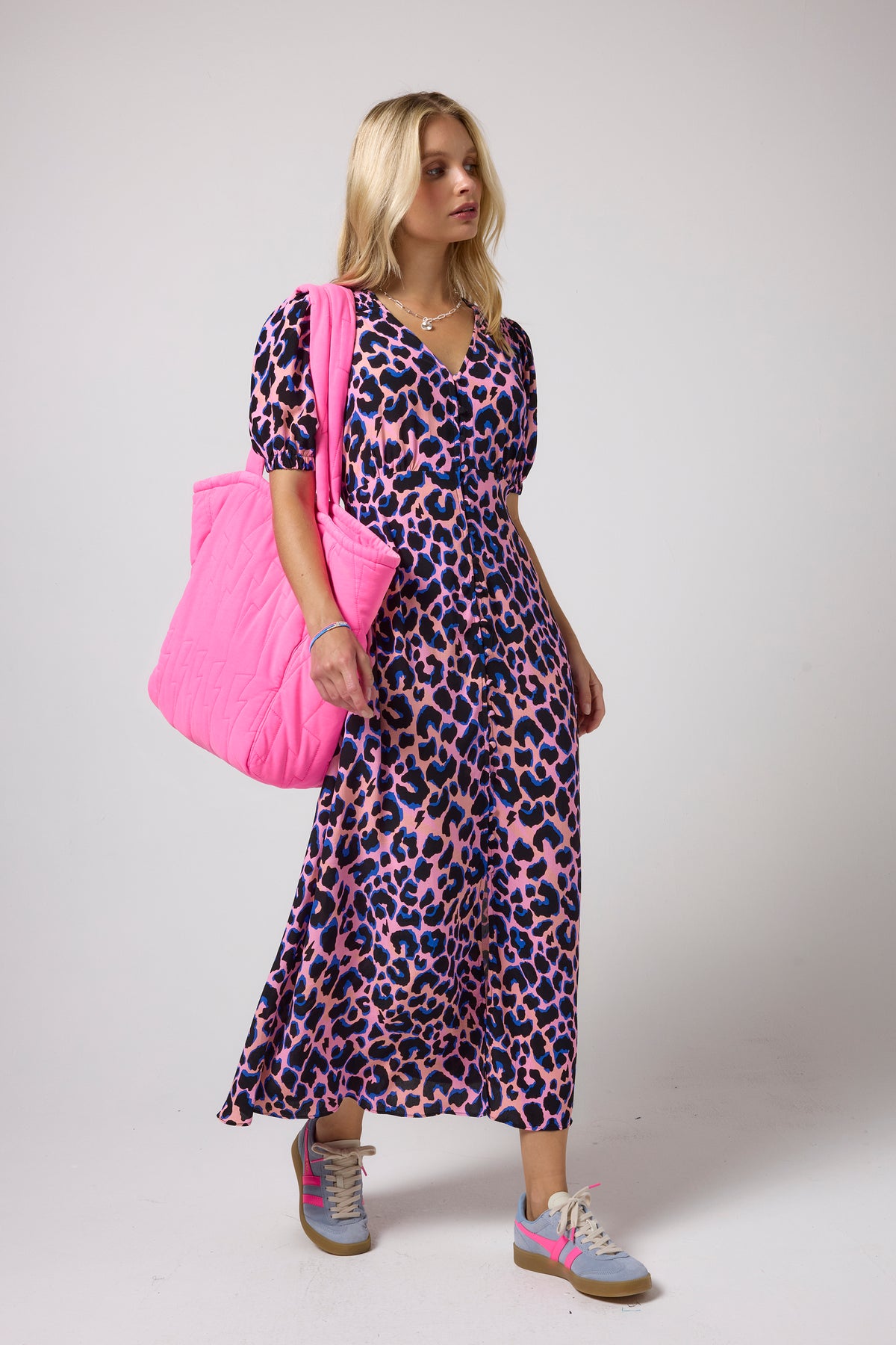 Scamp & Dude Pink with Blue Shadow Leopard Blouson Sleeve Midi Tea Dress | Model wearing a pink and blue leopard-print midi dress, carrying a large hot pink quilted tote bag.
