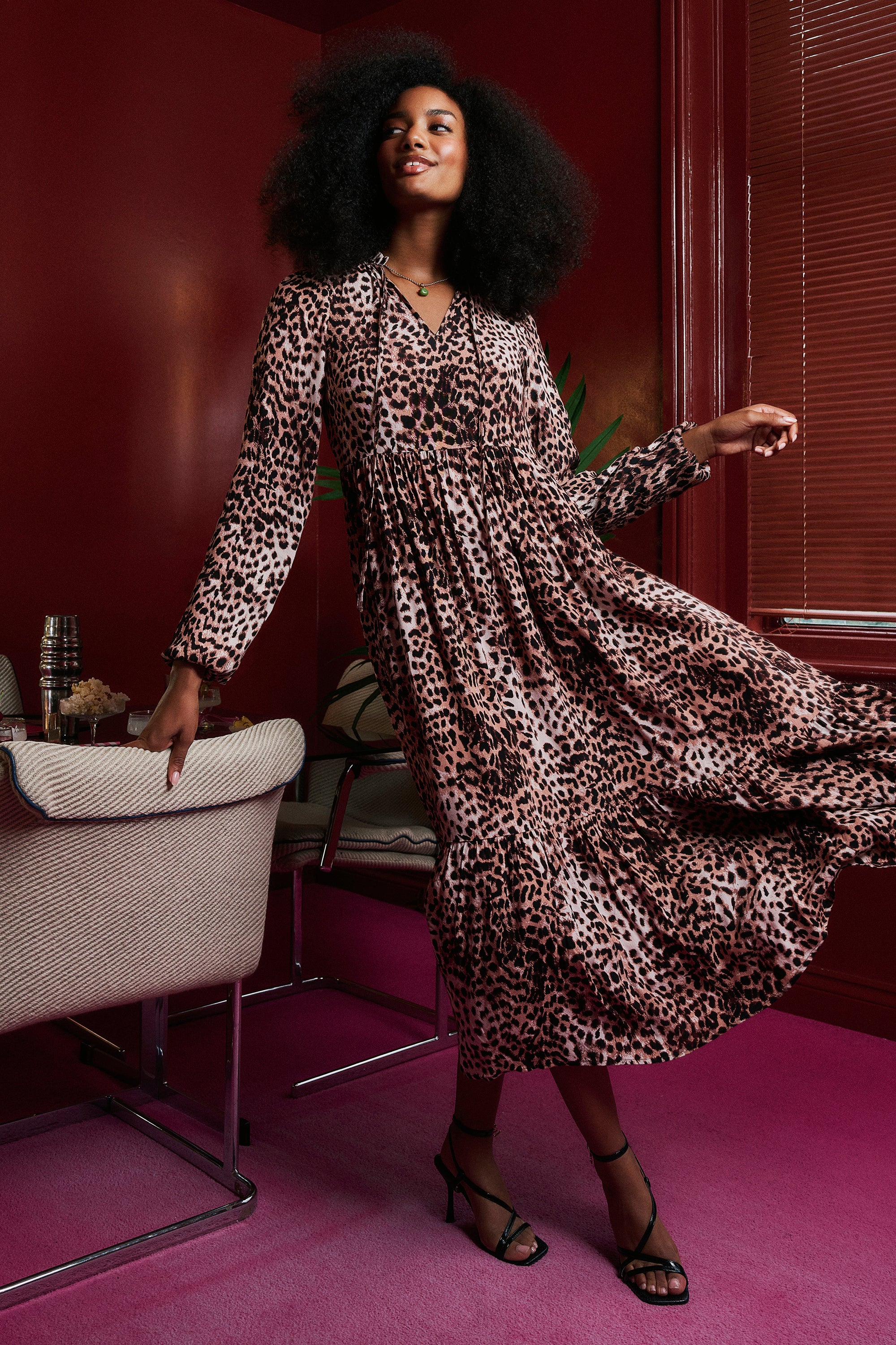 Scamp and Dude Neutral with Black Cheetah Blouson Sleeve Tie Front Midi Dress | Model wearing a neutral with black cheetah tie front midi dress with black heels.