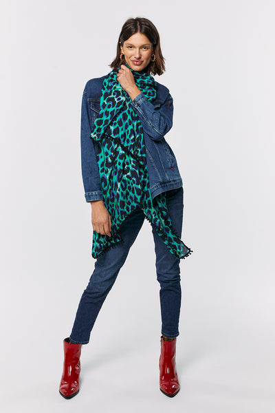 Scamp and Dude Green with Black and Blue Shadow Leopard Charity Super Scarf | Model with short hair wearing green and black patterned scarf wearing denim jacket and jeans