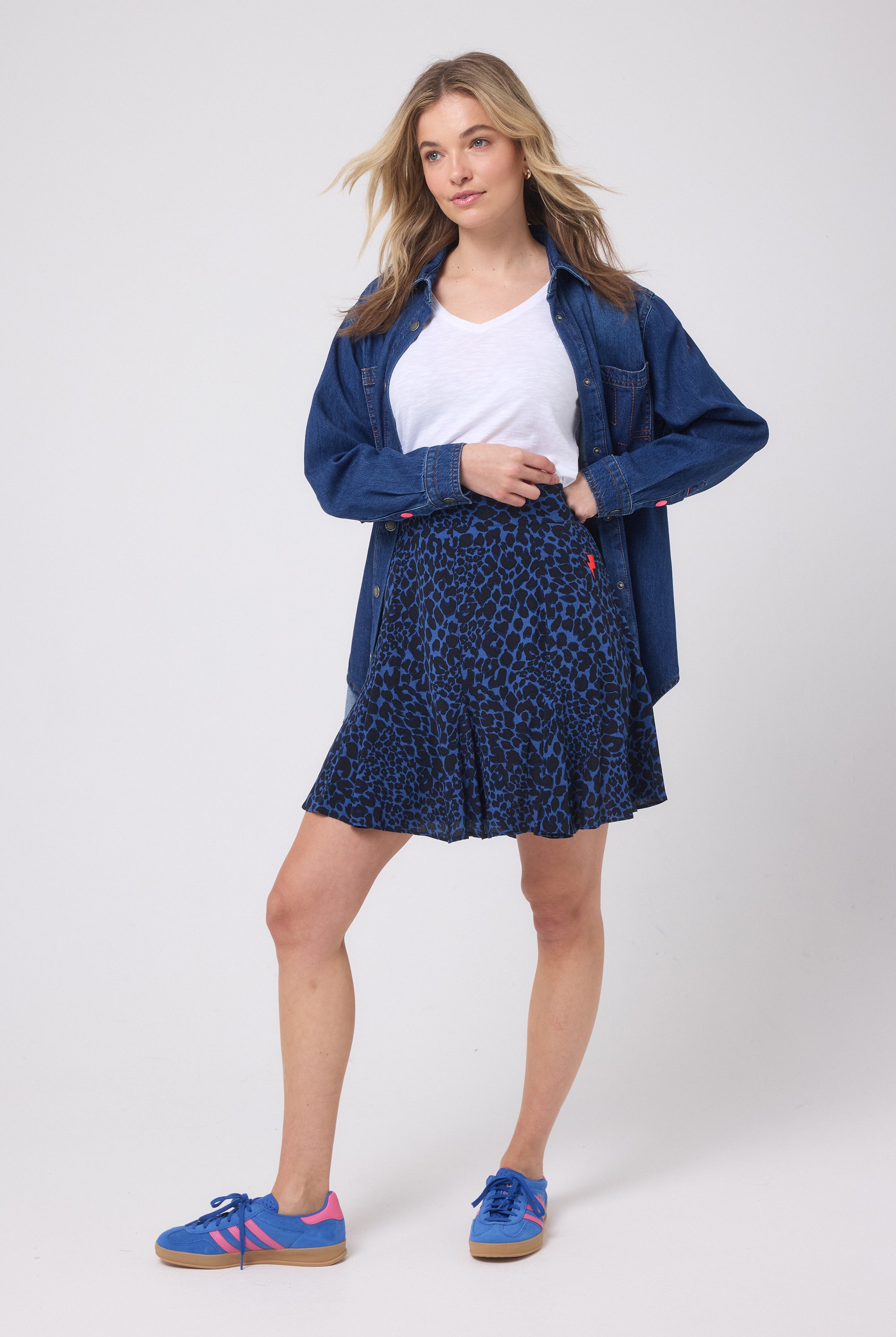 Scamp and Dude Navy with Black Rock and Roll Leopard Skater Skirt | Model wearing a navy leopard print skater skirt with a white v-neck t-shirt and a dark denim shirt.