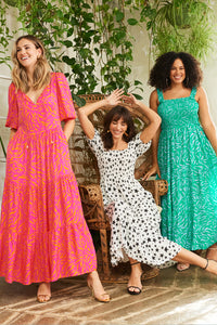 Three women wearing vibrant zebra or star Scamp & Dude dresses in different styles and colourways
