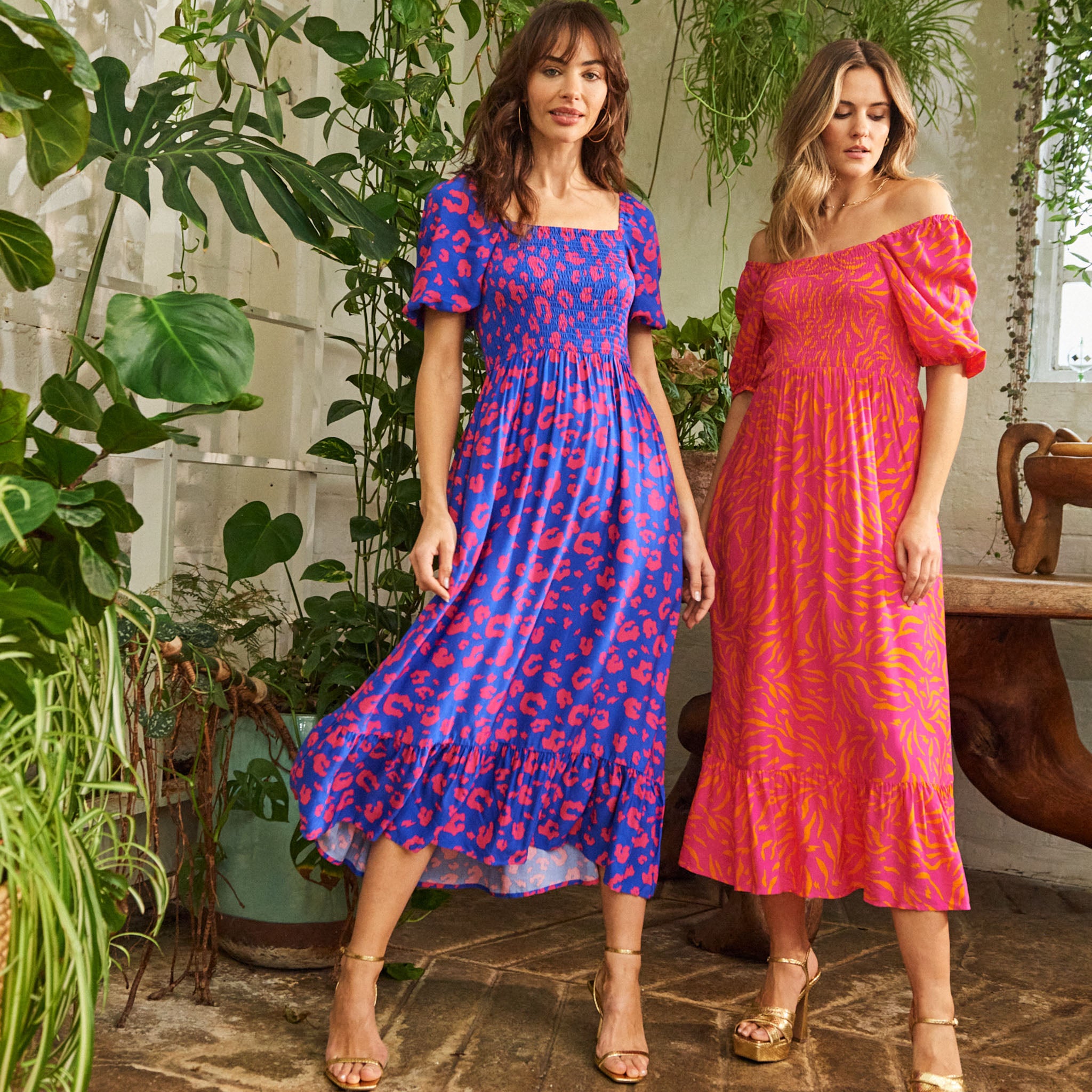 Two women wearing Scamp and Dude midi dresses with blouson sleeves in different animal prints & colours