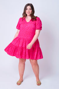 A lady swishing the skirt of her magenta with hot pink floral leopard and lightning bolt puff sleeve short dress 