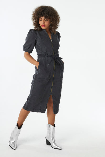 Scamp and Dude Washed Black Zip Detail Denim Dress | Model with curly hair looking away from camera wearing dark wash denim dress with silver cowboy boots 