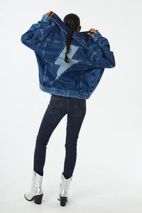 Scamp and Dude Indigo Wash Oversized Denim Jacket | Model facing away from the camera wearing a denim jacket with a denim lightening bolt on the back with denim jeans and silver cowboy boots