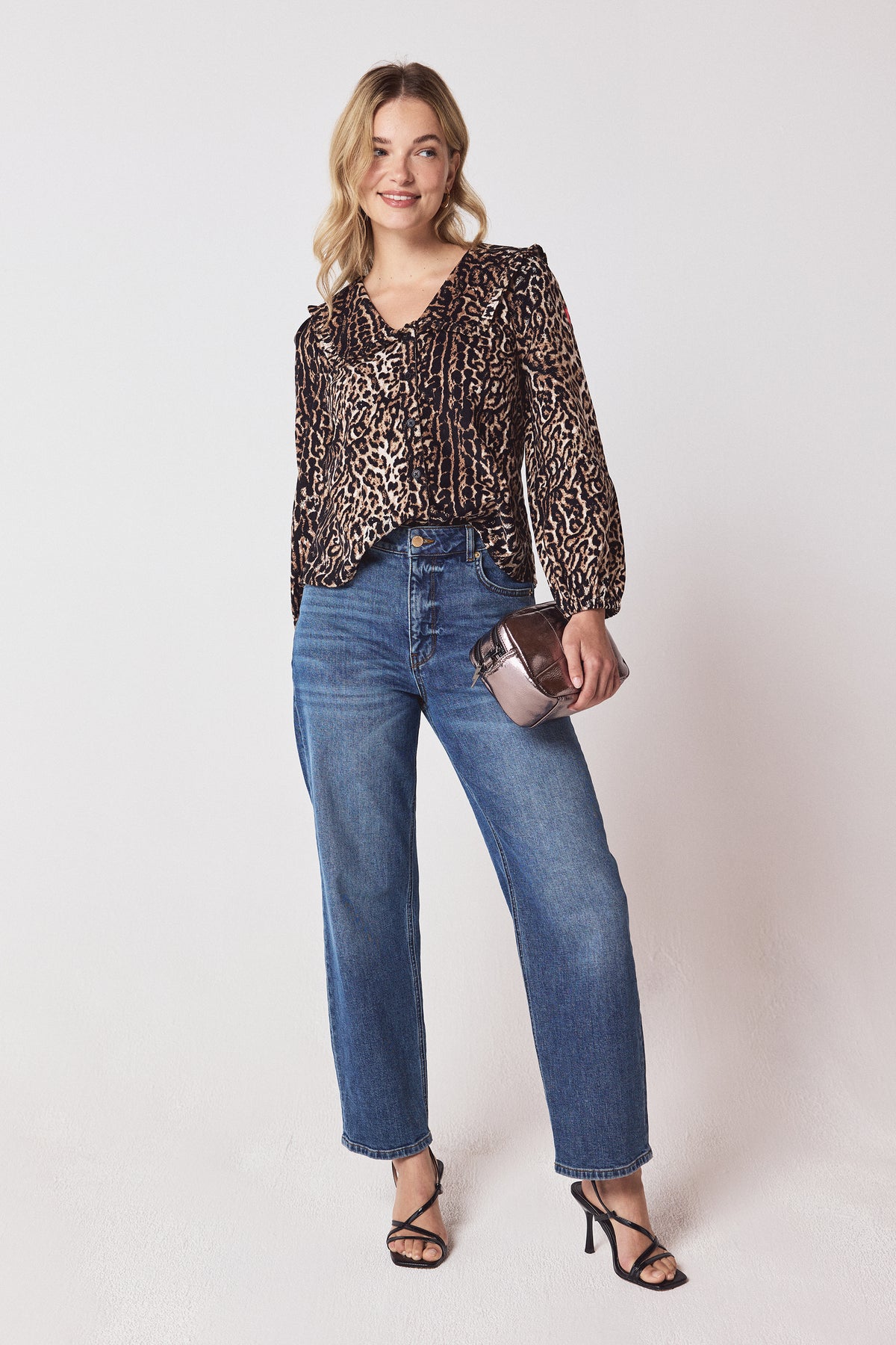 Scamp & Dude Neutral Milano Leopard Printed Cord Collared Blouse | Model wearing a neutral leopard long sleeve top with blue straight leg jeans and black heels.