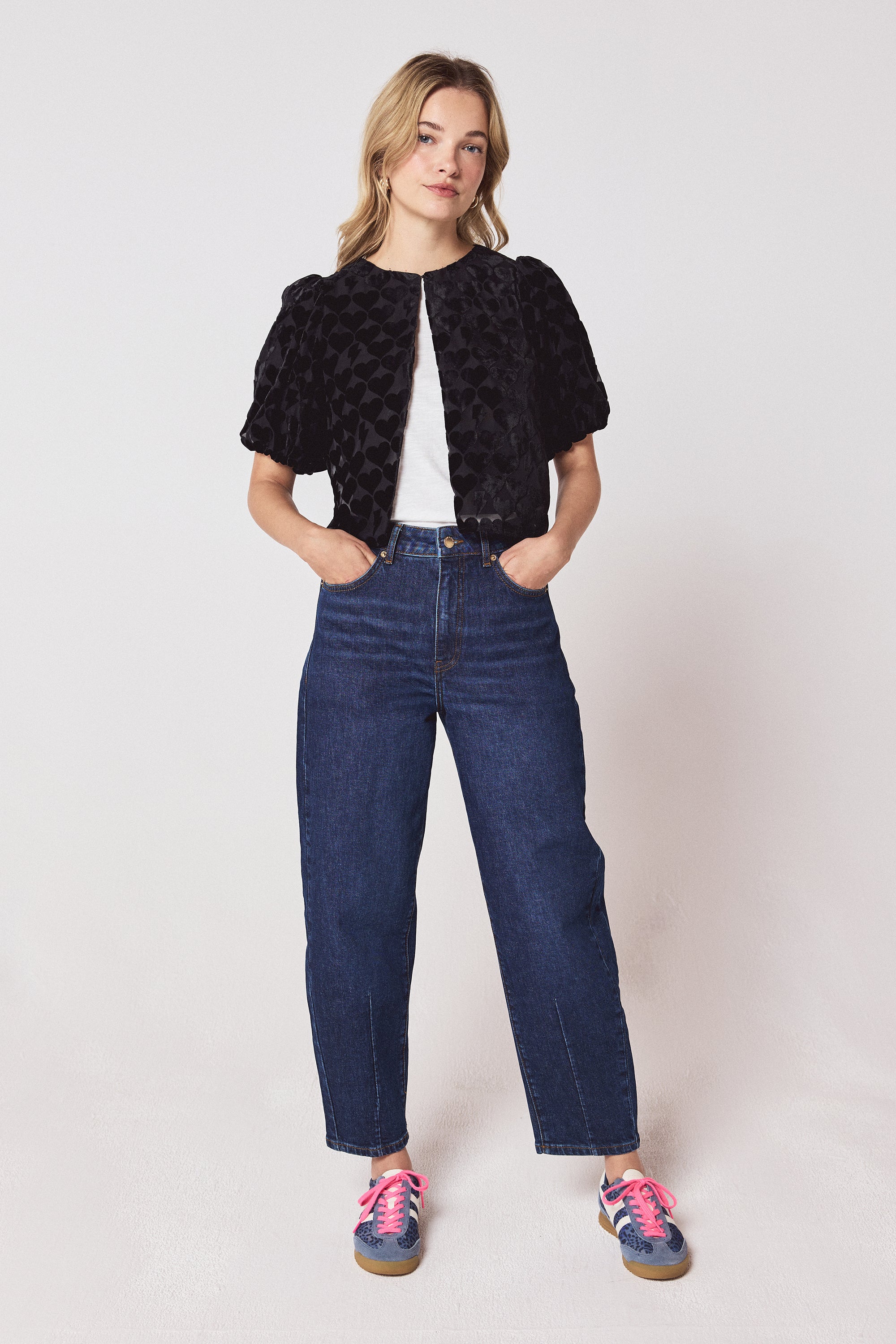 Scamp & Dude Black Heart & Bolt Burn Out Velvet Top | Model wearing a black velvet burn out top with a pair of barrel leg jeans and navy cheetah print trainers.
