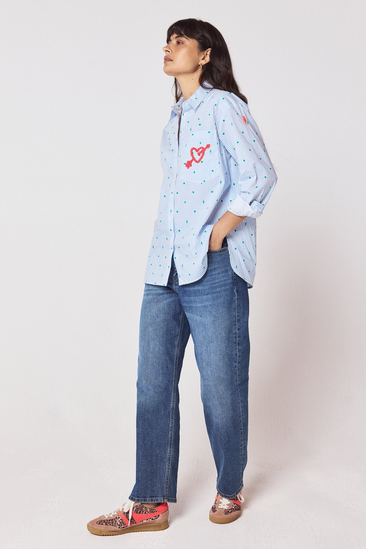 Scamp & Dude Blue Polka Dot Bolt Stripe Shirt | Model wearing a light blue button-up shirt with a small blue polka dot pattern, paired with blue jeans and colourful trainers.