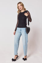 Scamp & Dude Black Embellished Mesh Top | Model wearing a black mesh top with pale blue jeans and black bow heels.
