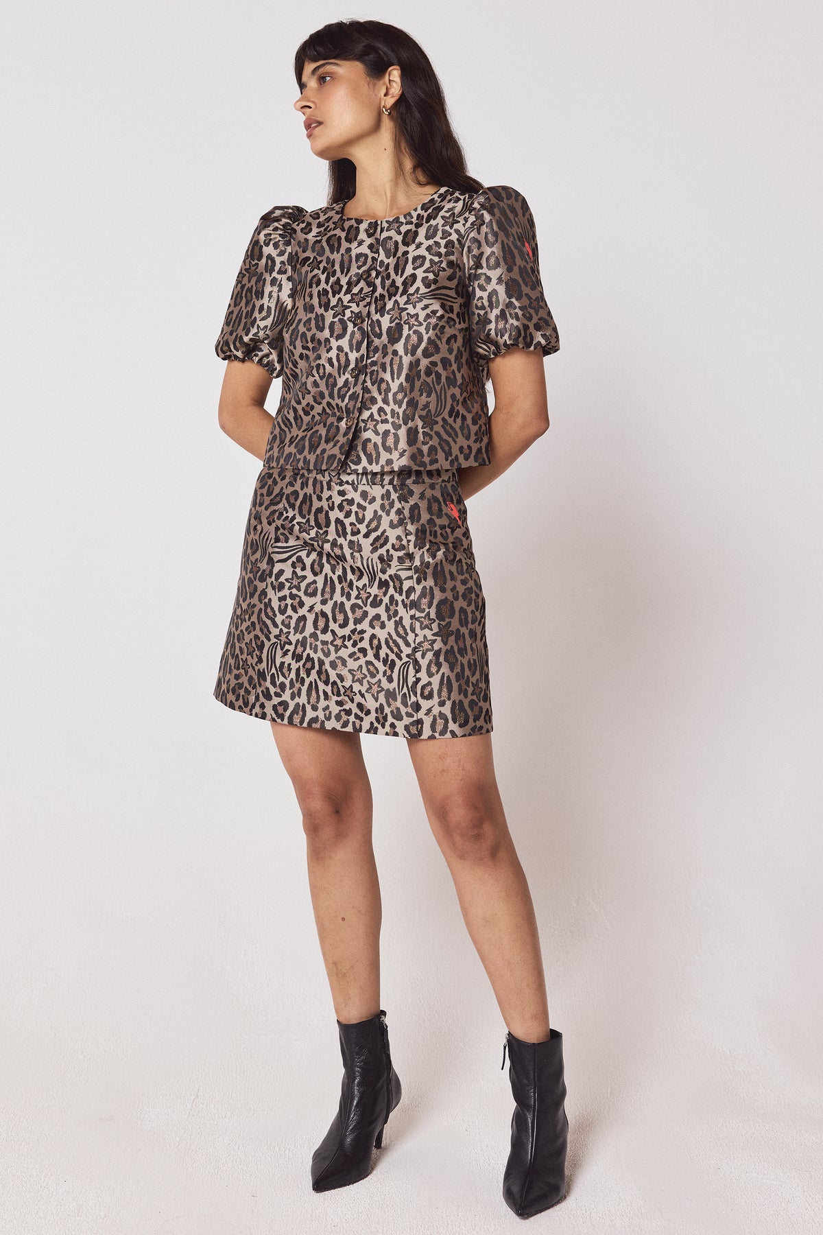Scamp & Dude Neutral Star Leopard Jacquard Top | Model wearing a neutral star leopard print top with a matching skirt and black heeled boots.