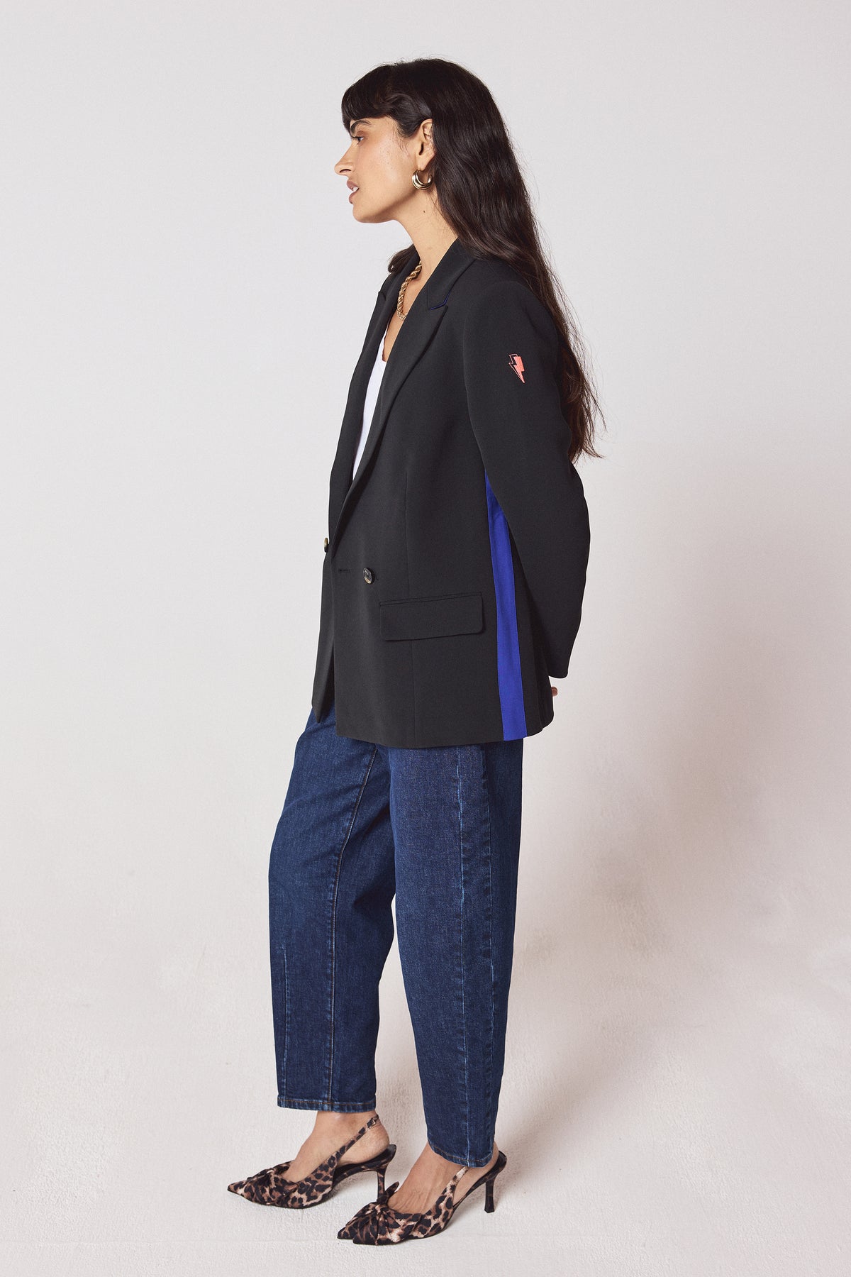 Scamp & Dude Black with Blue Side Stripe Blazer | Model wearing a black blazer with blue side stripe and blue barrel jeans. Worn with leopard heels.
