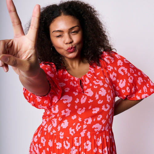 Scamp and Dude Pink with Red Leopard Maxi Sundress | Model with curly hair pouting with fingers in peace sign wearing pink and red leopard print dress 
