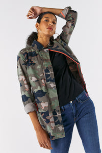 Scamp and Dude Khaki Camo Print Utility Jacket | Model with hand placed on head wearing camo print jacket with black top and skinny blue denim jeans