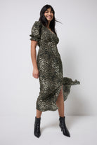 Scamp and Dude Khaki Cheetah Flute Sleeve Midi Tea Dress | Model wearing a khaki cheetah flute sleeve midi tea dress with black heeled boots.