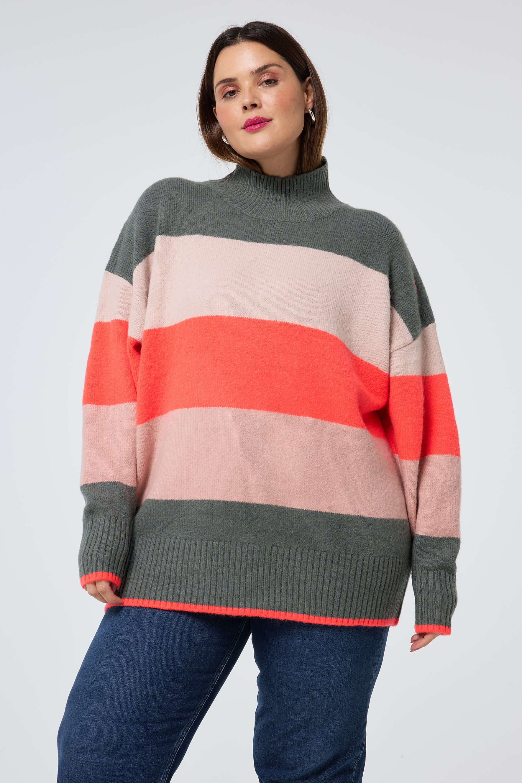 Scamp and Dude Multi Colour Oversized Turtle Neck Jumper | Model wearing a turtleneck knit jumper with indigo jeans.