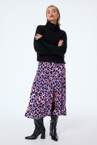 Scamp and Dude Pink with Blue and Black Shadow Leopard Split Front Skirt | Model wearing a pink midi skirt with blue and black shadow leopard paired with a black turtle neck jumper/