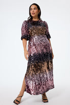 Scamp and Dude Pink Ombre Sequin Puff Sleeve Midi Dress | Model wearing a midi puff sleeve dress with ombre sequin detail paired with black heels.