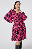 Scamp and Dude Pink with Red and Black Pop Leopard Blouson Sleeve Godet Short Dress | Model wearing a long sleeve pink short dress that features red and black leopard print. Worn with knee high black boots.