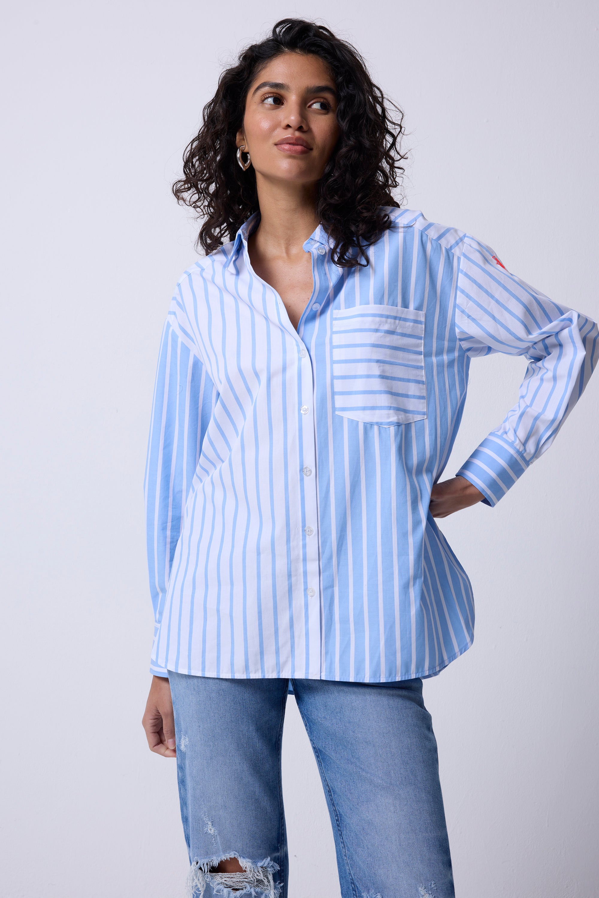 Scamp and Dude Blue and White Stripe Oversized Shirt | Model wearing a blue and white stripe shirt in an oversized fit, paired with distressed blue jeans.