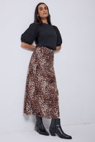 Scamp and Dude Neutral with Black Cheetah Split Front Skirt | Model wearing a black pintuck sleeve t-shirt with a neutral and black cheetah print skirt. Paired with black boots.