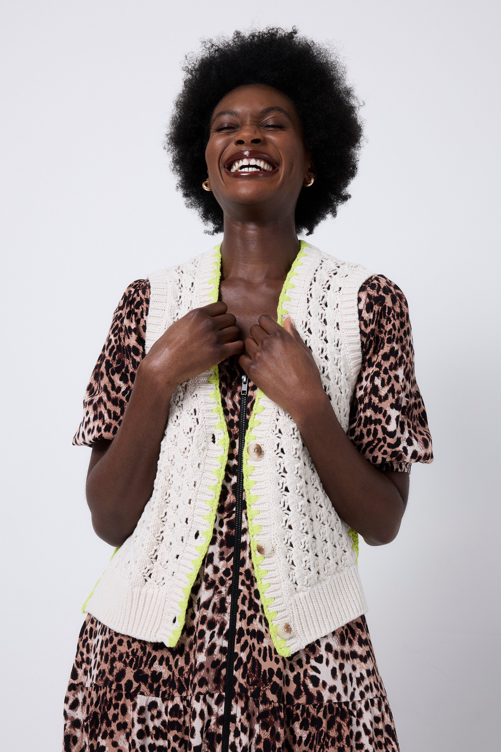 Scamp and Dude Cream with Neon Yellow Knitted Crotchet Waistcoat | Model wearing a neutral cheetah print dress with a cream knitted waistcoat with neon yellow trim over the top.