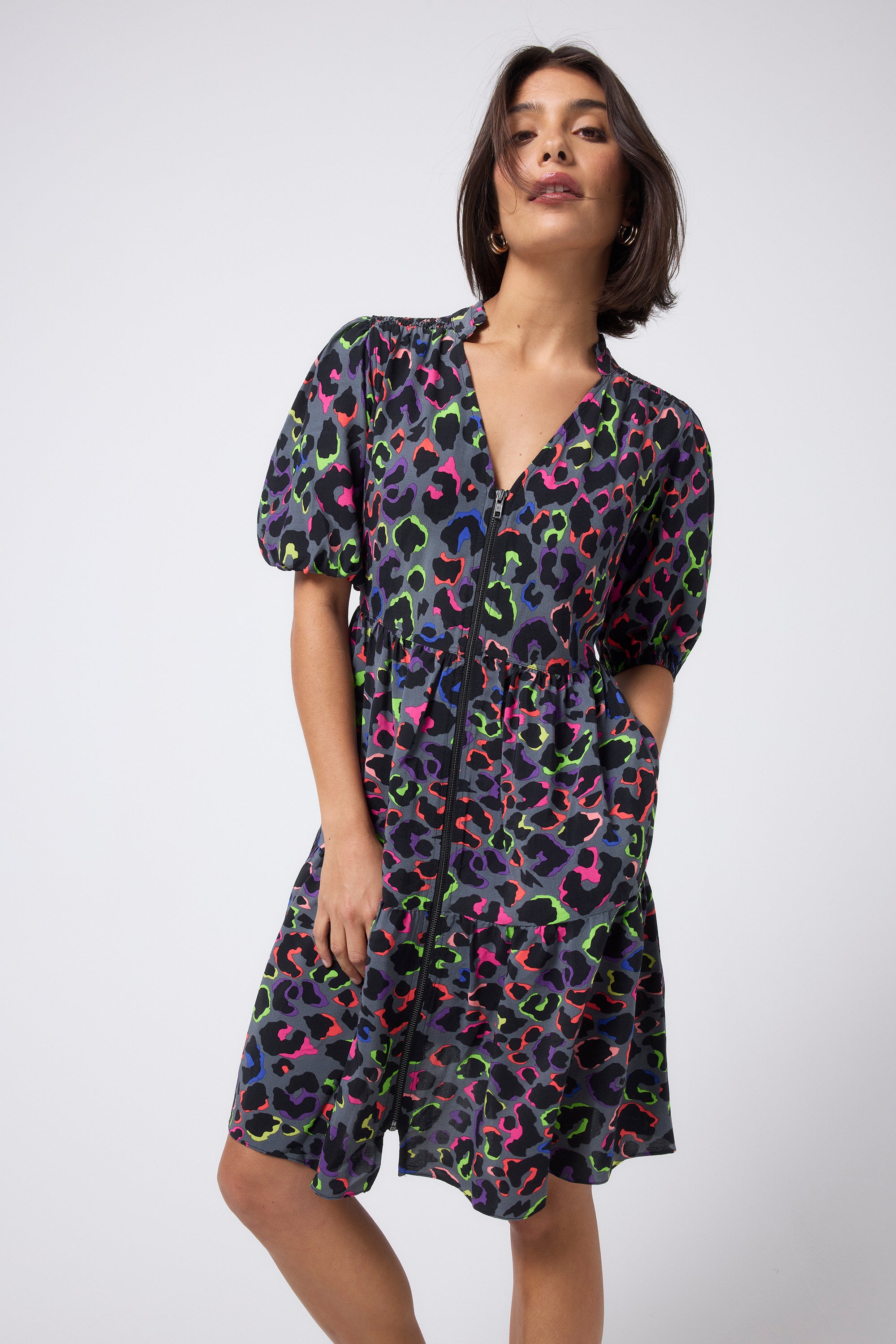 Scamp and Dude Grey with Rainbow Shadow Leopard Zip Detail Tiered Short Dress | Model wearing a grey short sleeve zip front mini dress with rainbow shadow leopard print.