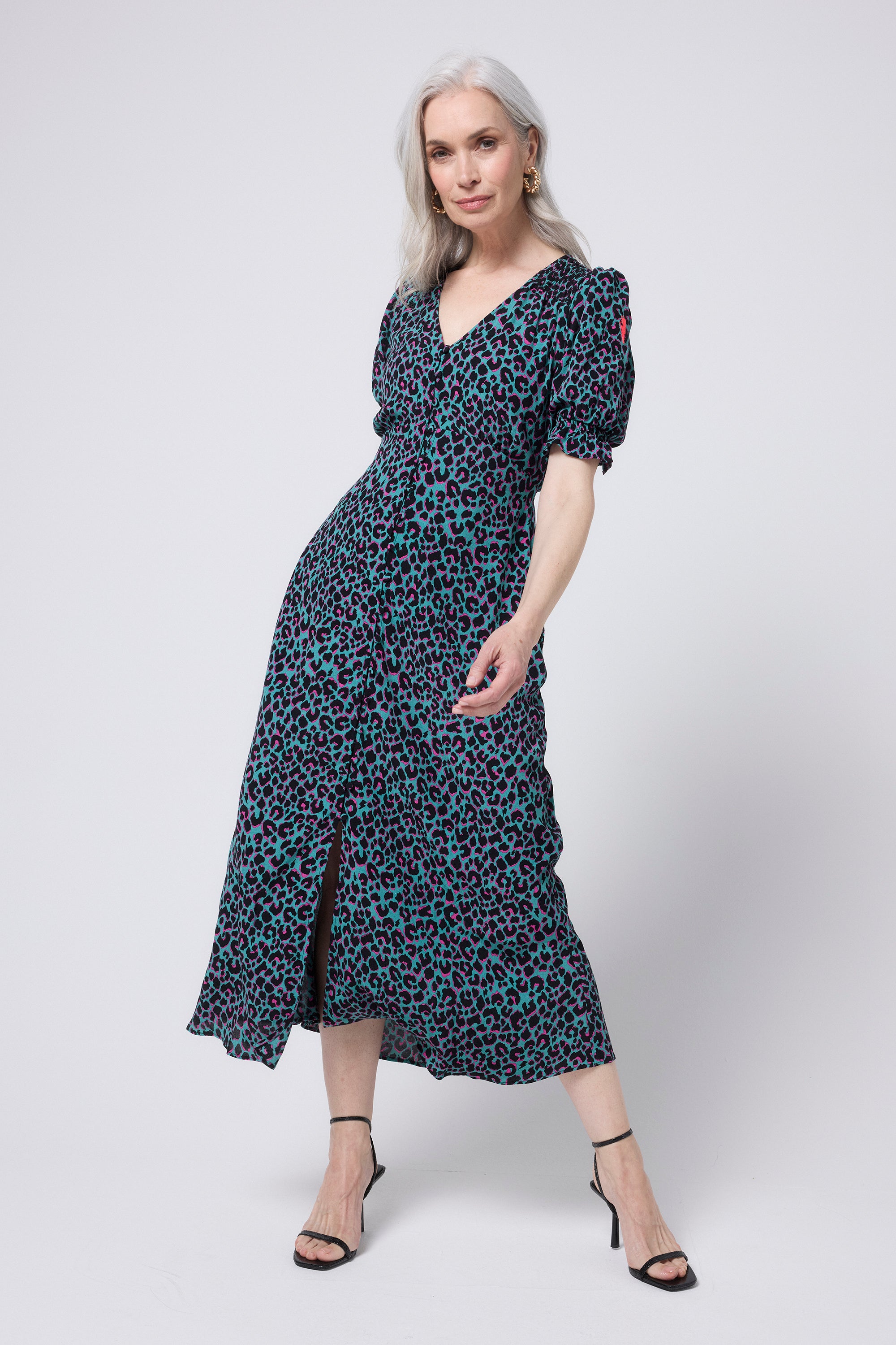 Scamp and Dude Khaki with Pink and Black Small Shadow Leopard Flute Sleeve Midi Tea Dress | Model wearing short sleeve khaki midi dress with a pink and black leopard print. Worn with black heels and chunky gold earrings.